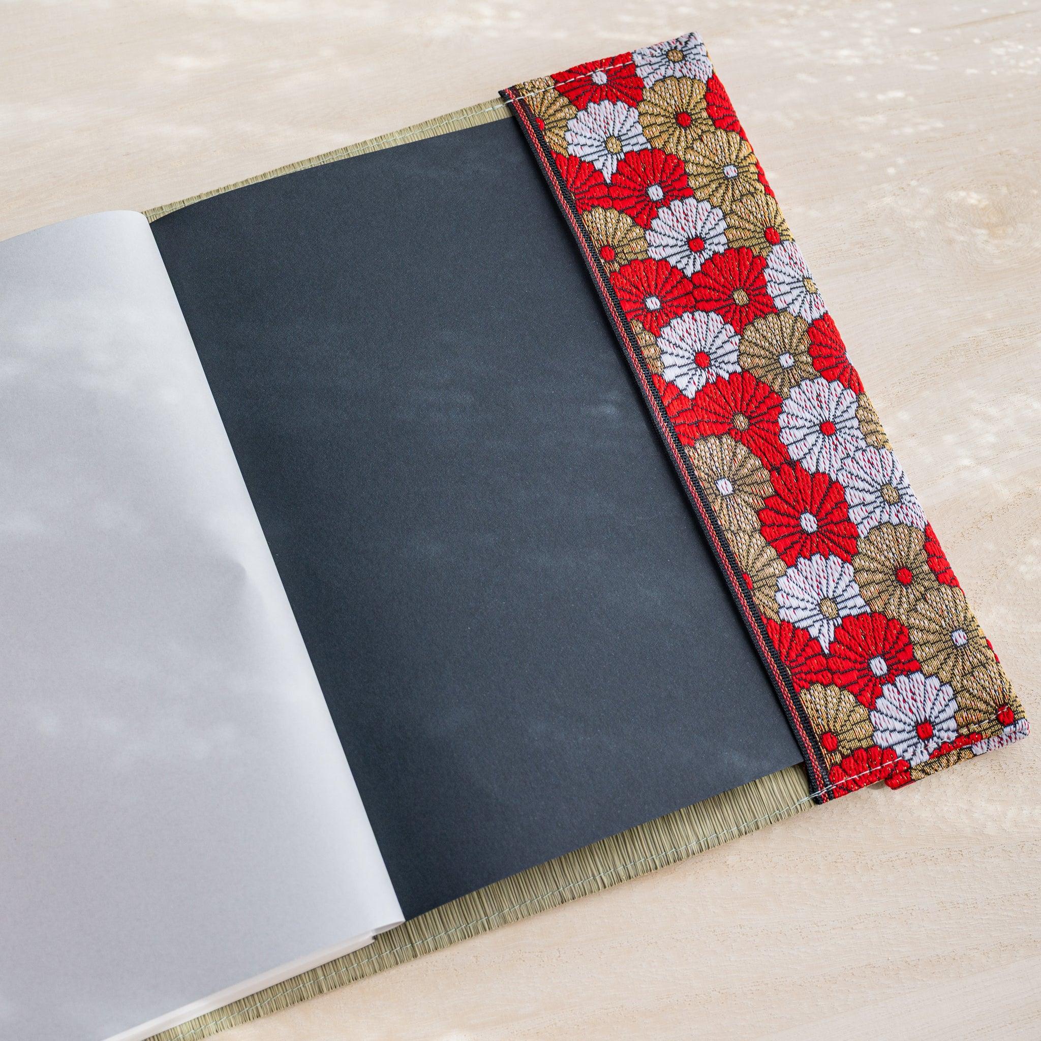 Tatami book cover inner flap open showing black notebook cover and red white and gold chrysanthemum fabric band