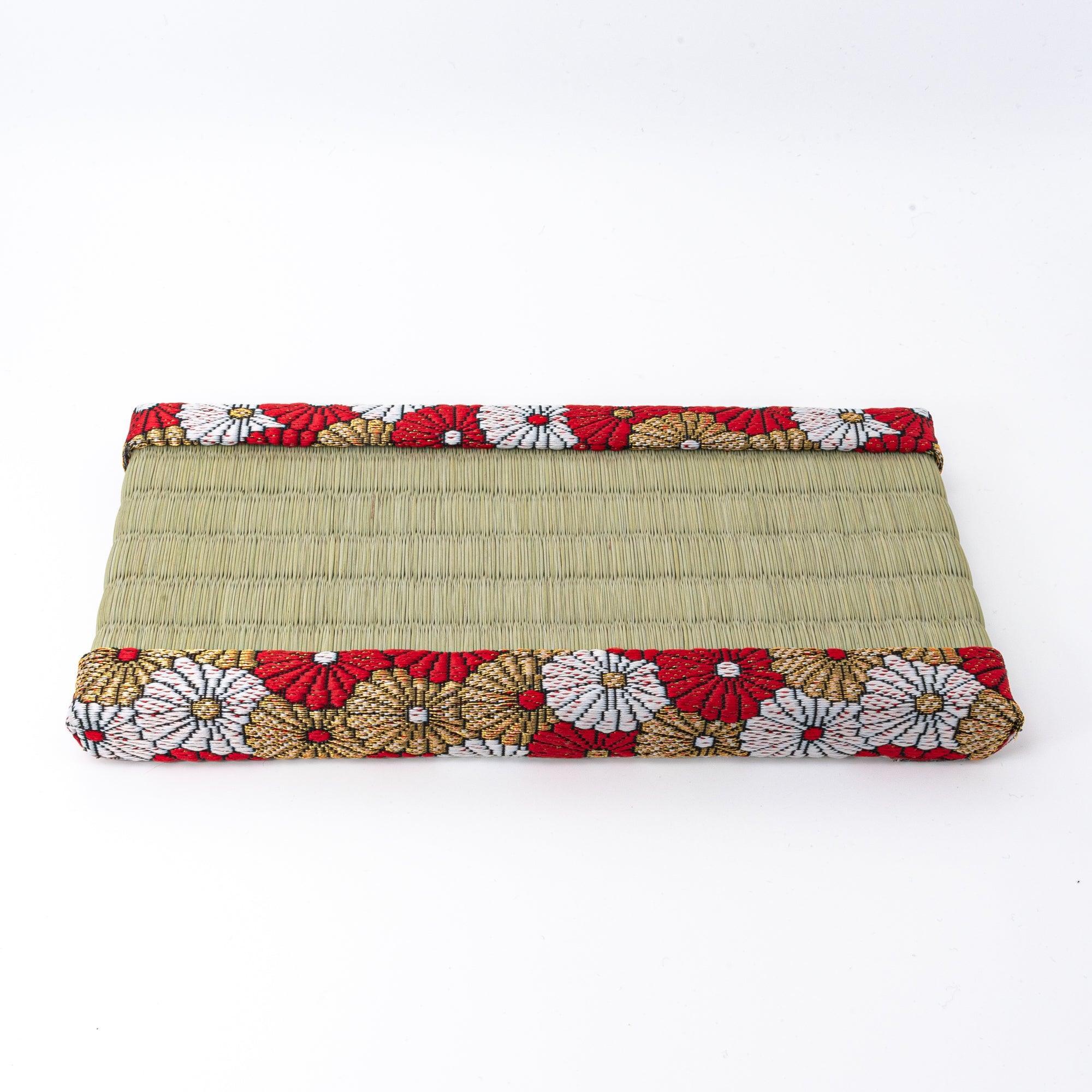 Japanese tatami pen tray with chrysanthemum brocade border shown empty from front, displaying igusa surface and brocade edges