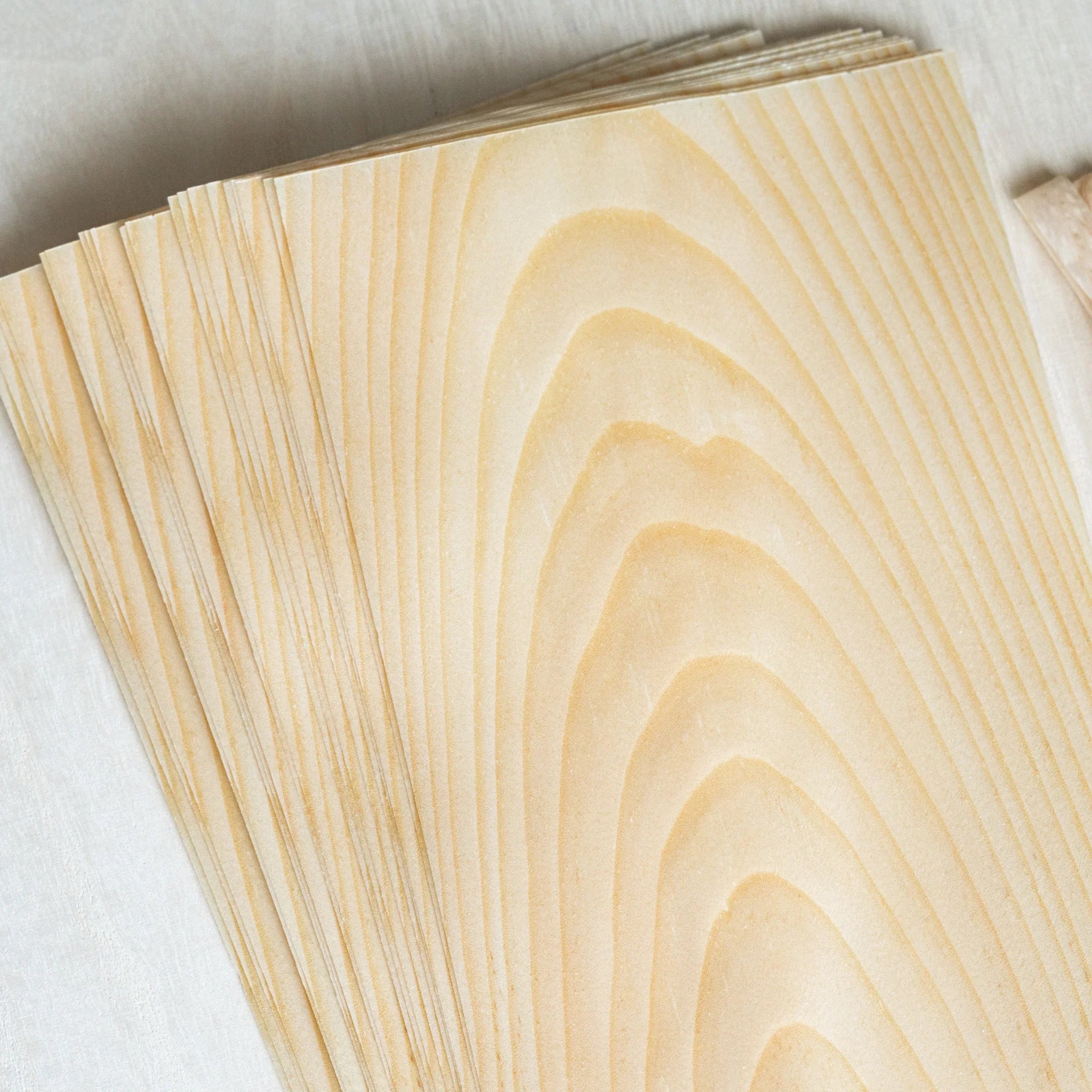 Close-up of fanned Red Pine Wood Craft Sheets showing natural grain in pale yellow tones