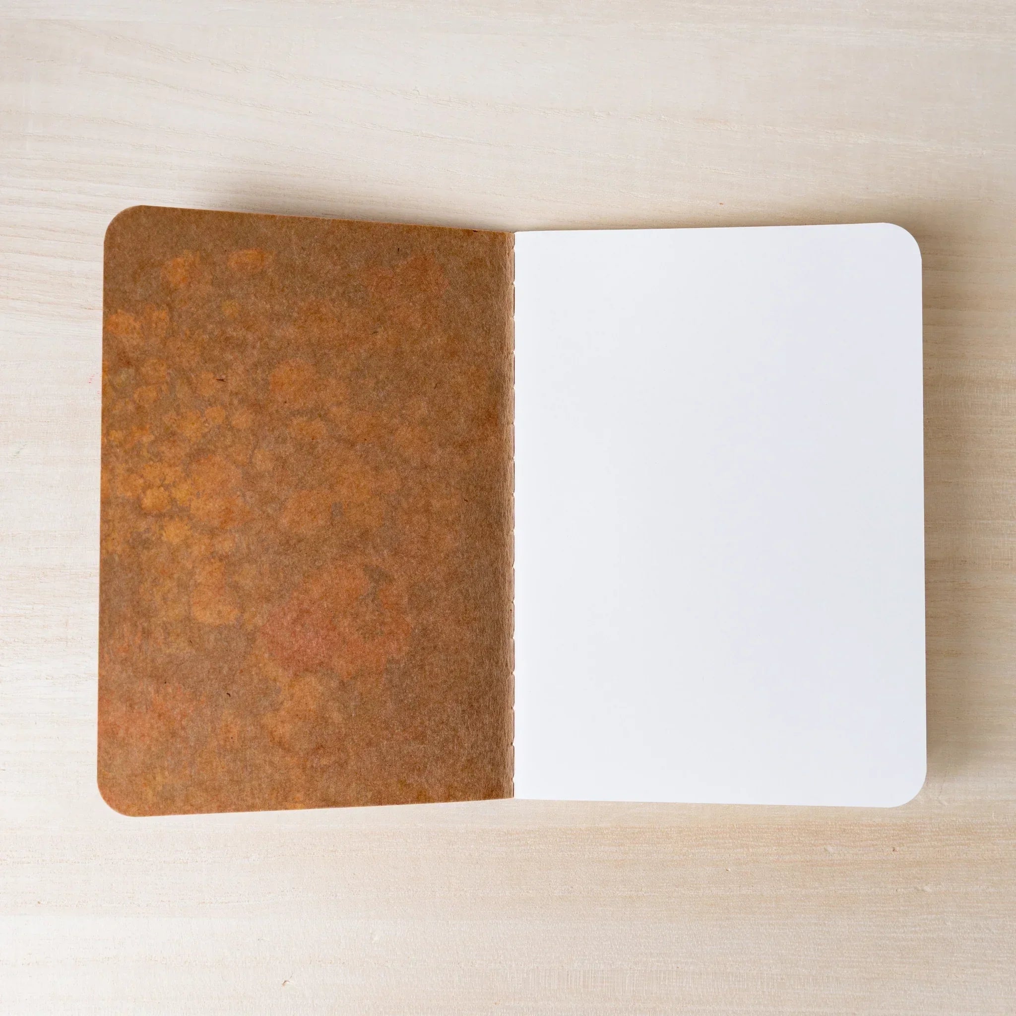 RO-BIKI NOTE open flat, brown waxed kraft paper inner cover on left, blank white page on right, rounded corners