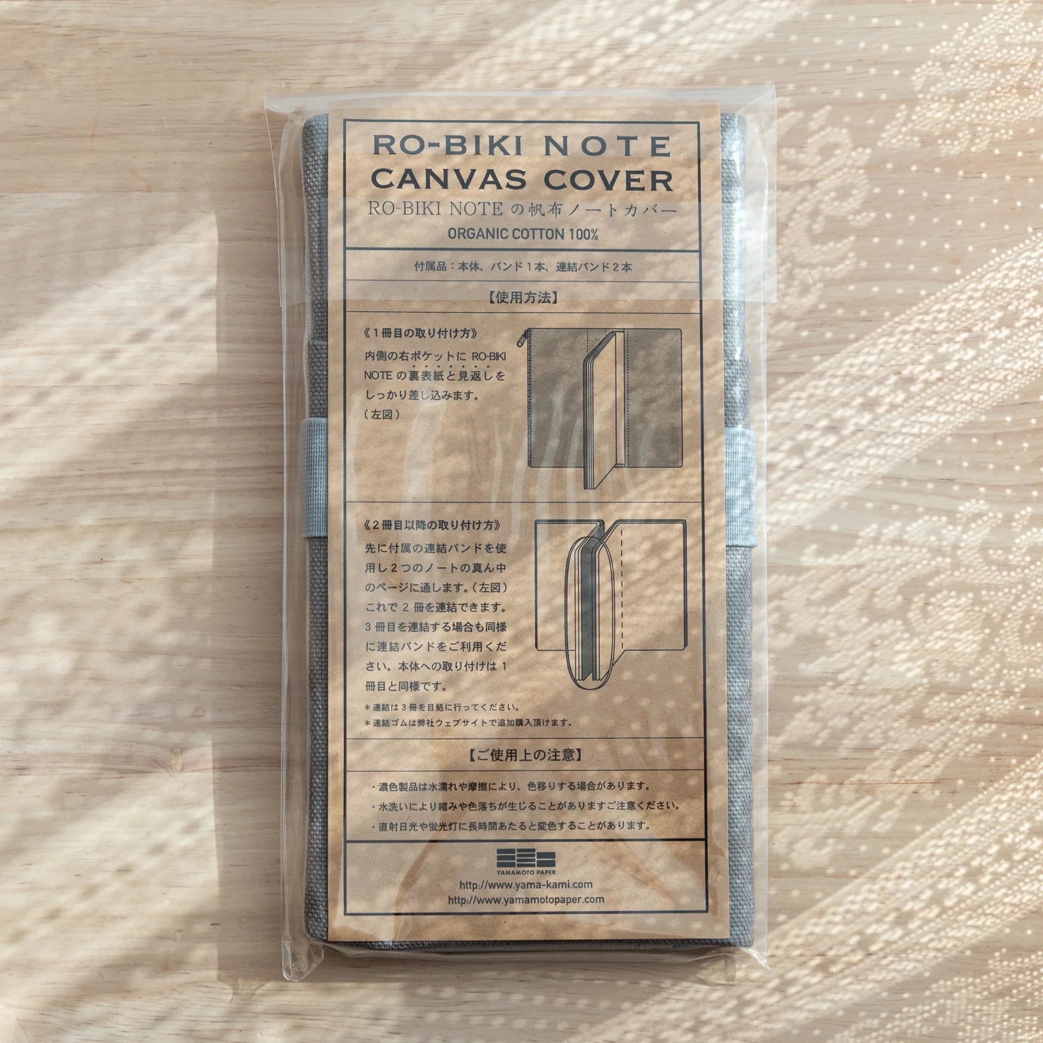 Instruction sheet on RO-BIKI Canvas Cover Cool Gray packaging, showing usage with Japanese Note Book and pens.