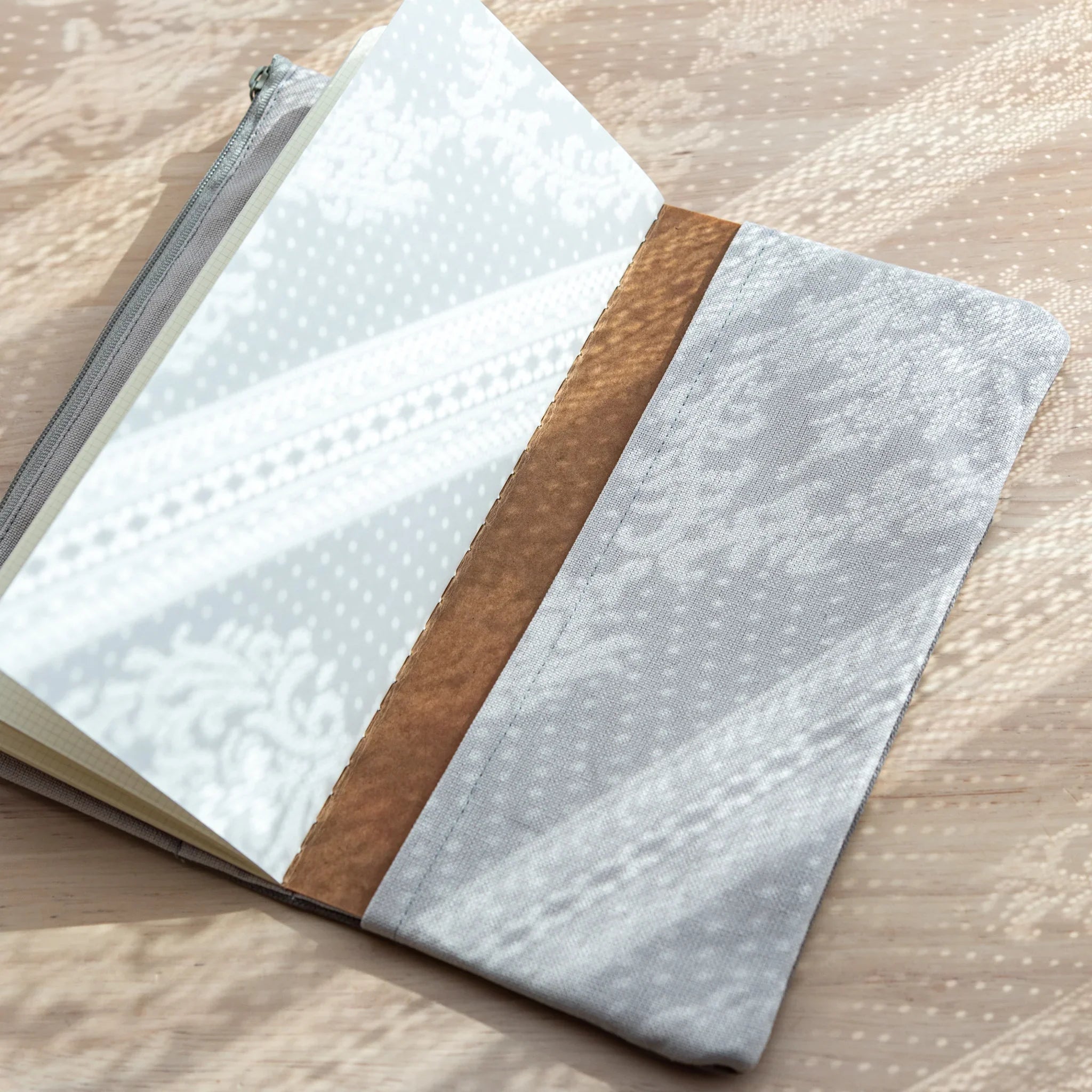 Open view of RO-BIKI Canvas Cover in Cool Gray, showing notebook securely held inside with organic cotton lining.