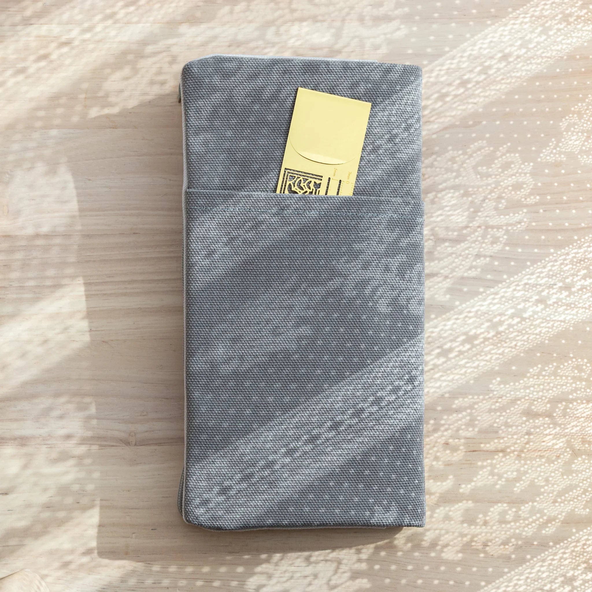 Back view of RO-BIKI Canvas Cover Cool Gray with external slip pocket holding a gold ruler behind Japanese Note Book.