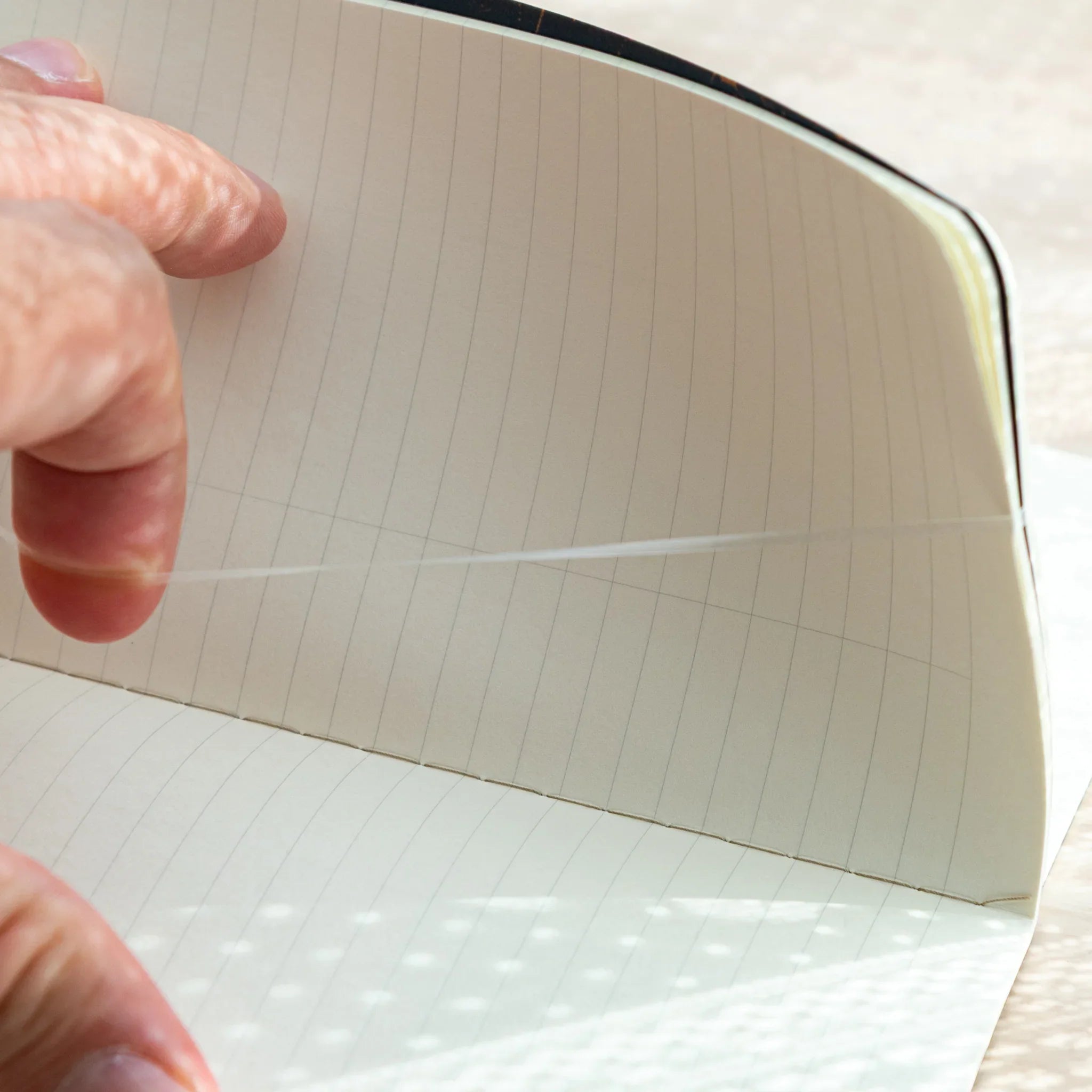 Close-up of RO-BIKI Canvas Cover, Japanese Note Book Cover, showing notebook binding with connecting band inside.
