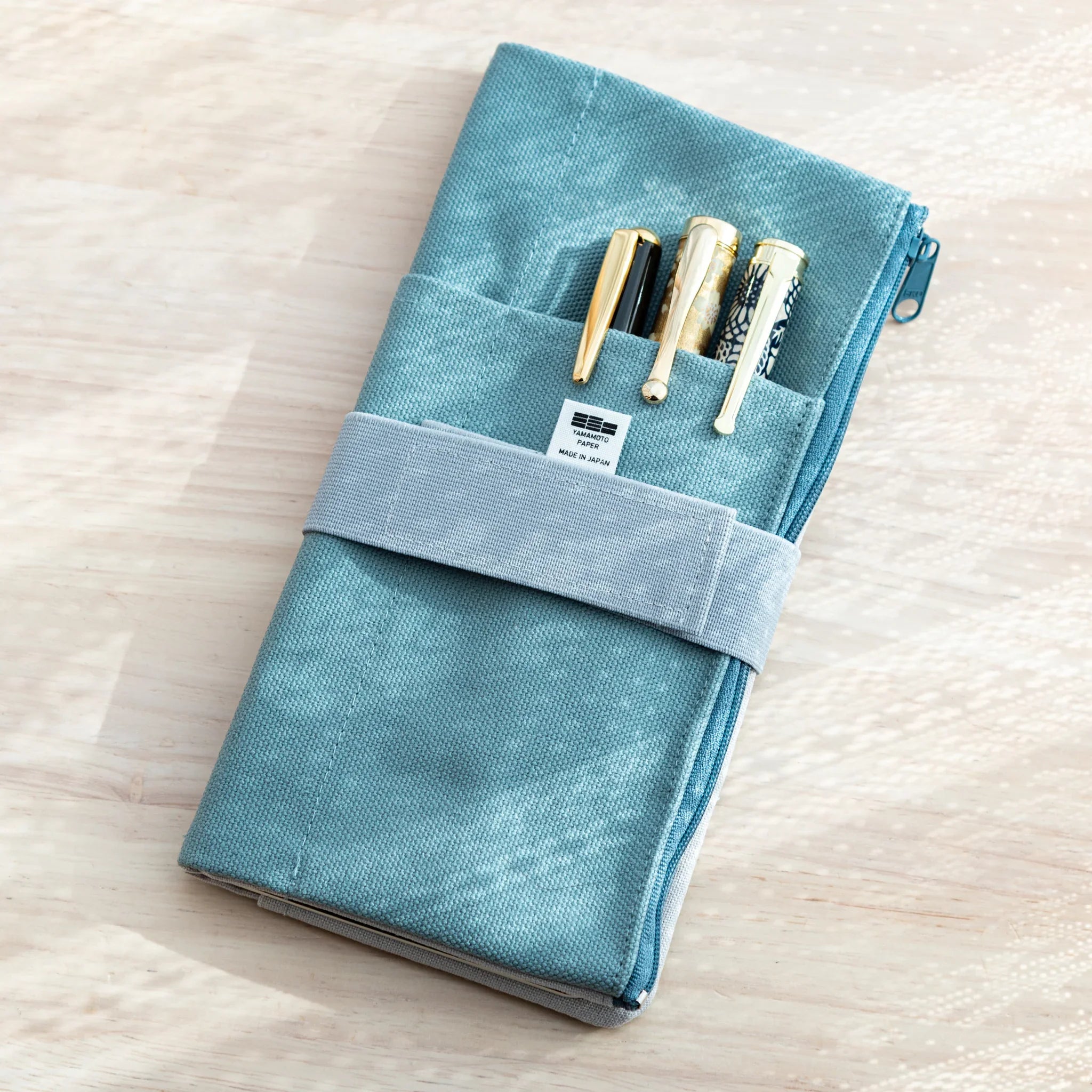 Japanese Notebook Cover with outer pen pockets, neatly holding three stylish pens.