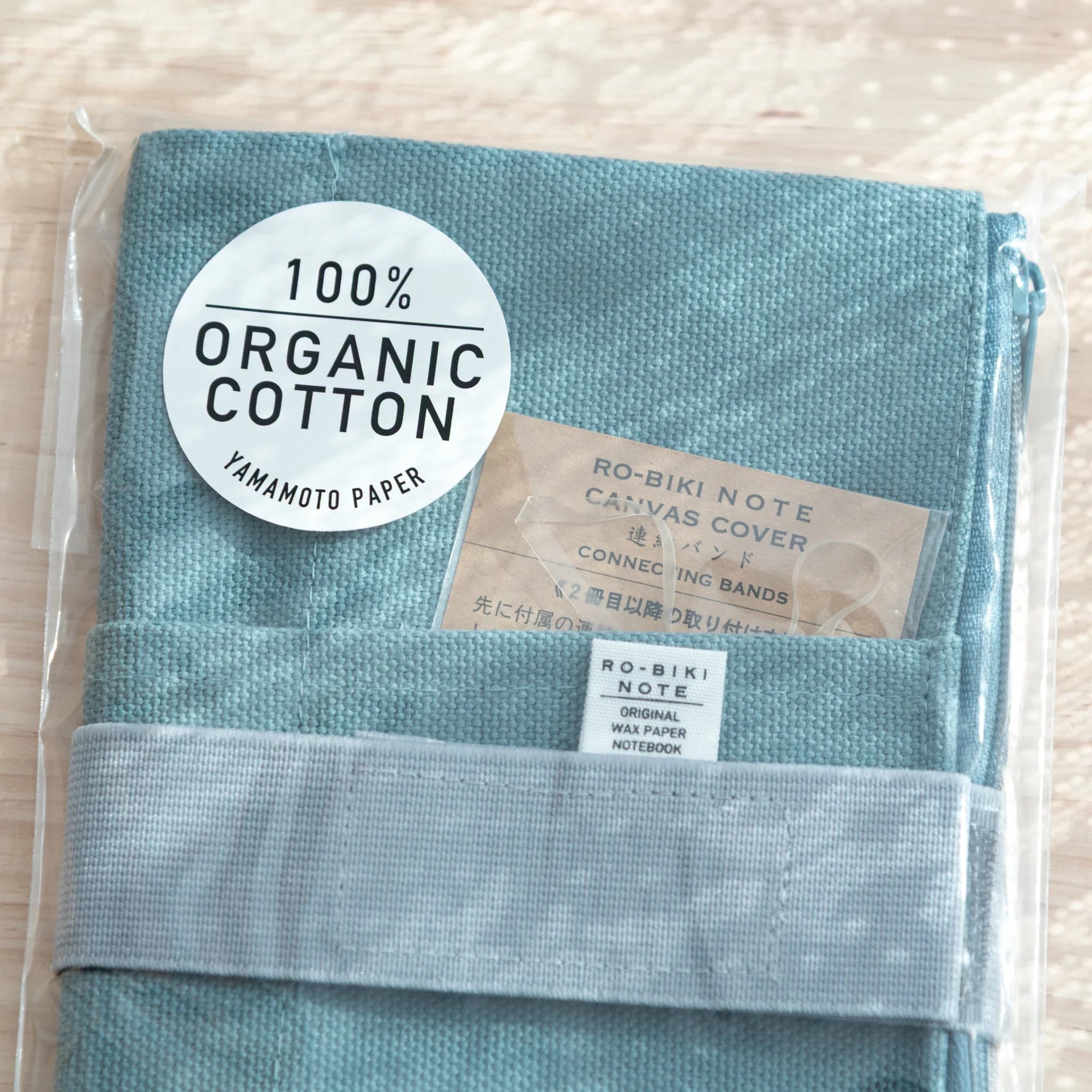 Packaging label of Japanese Notebook Cover, showing 100% organic cotton detail.