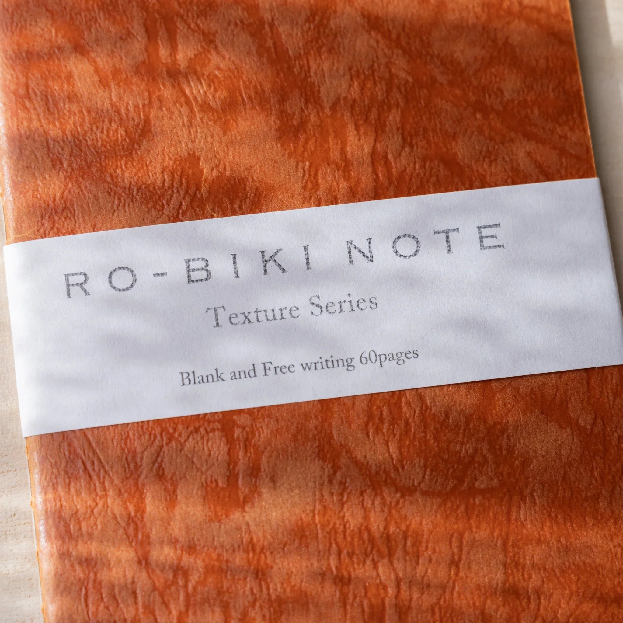 Close-up of RO-BIKI NOTE Texture Series label on Edocha Brown wax-coated cover showing blank 60-page notebook detail