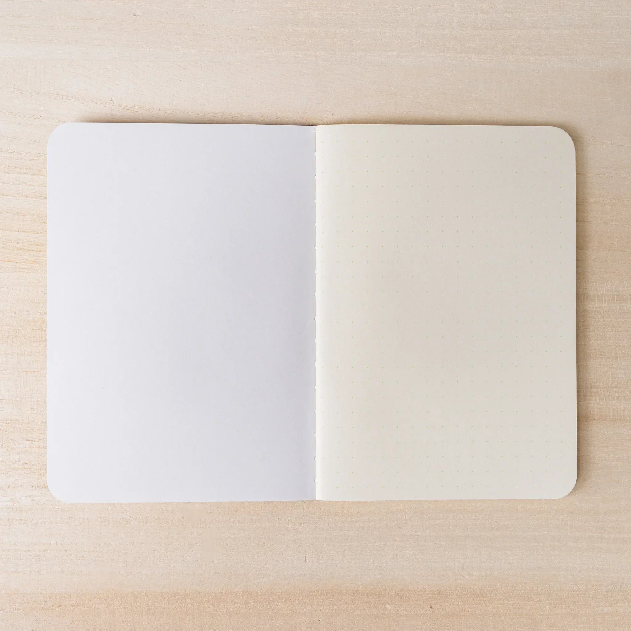 RO-BIKI NOTE open flat, blank white page on left, ivory dot grid page on right, rounded corners and center spine visible