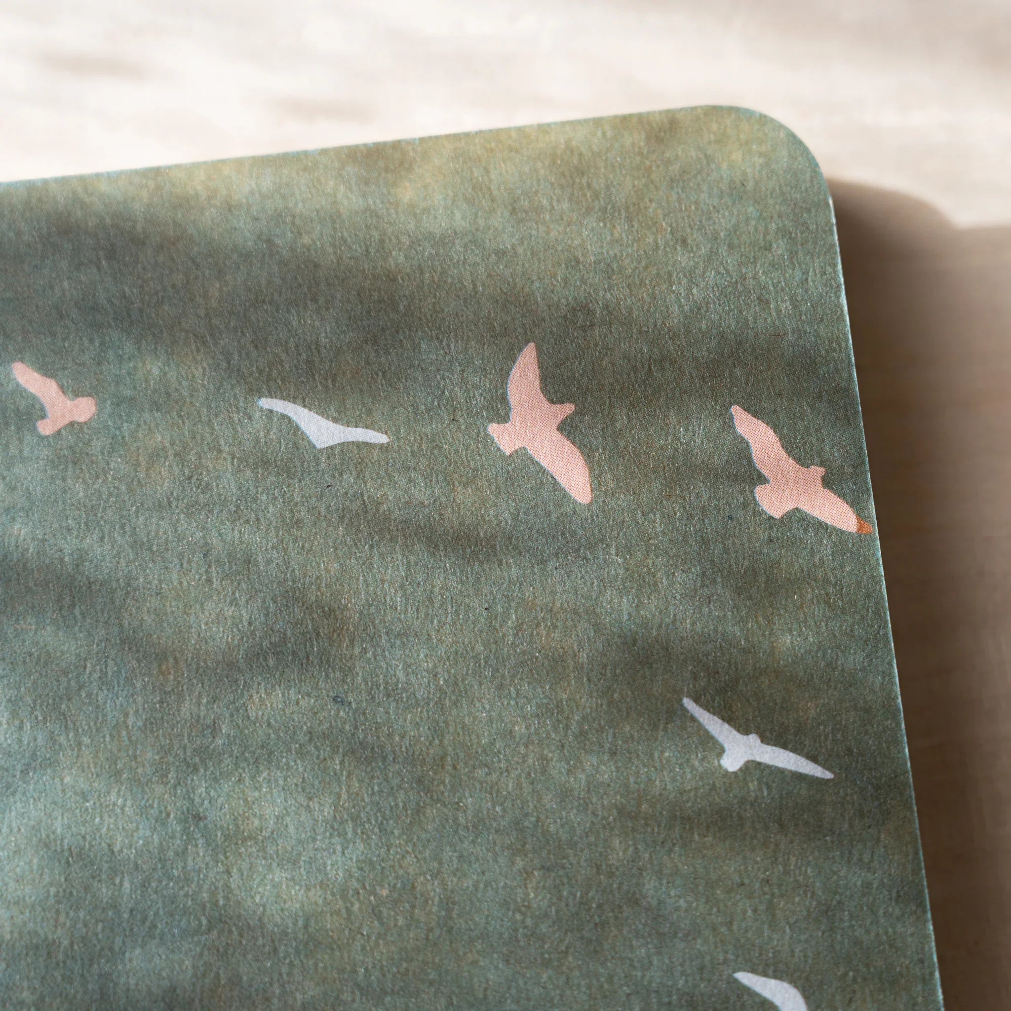 RO-BIKI NOTE top corner showing sage green waxed cover with flying bird design, rounded corner visible