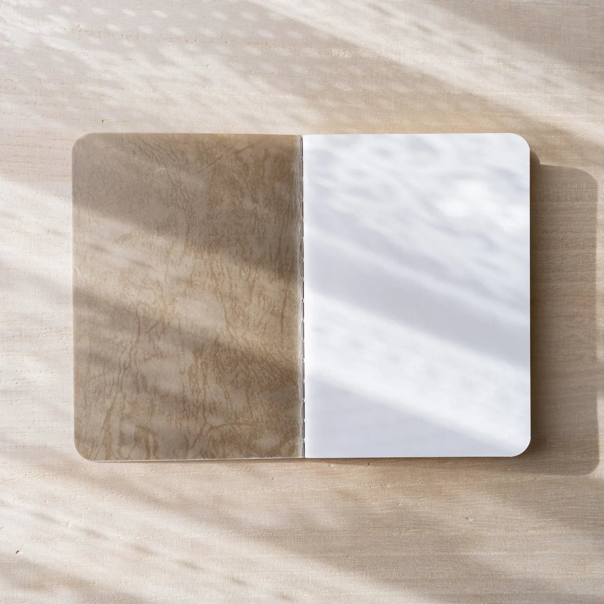 RO-BIKI NOTE open to cream blank page spread, rounded corners and center spine visible, clean paper texture