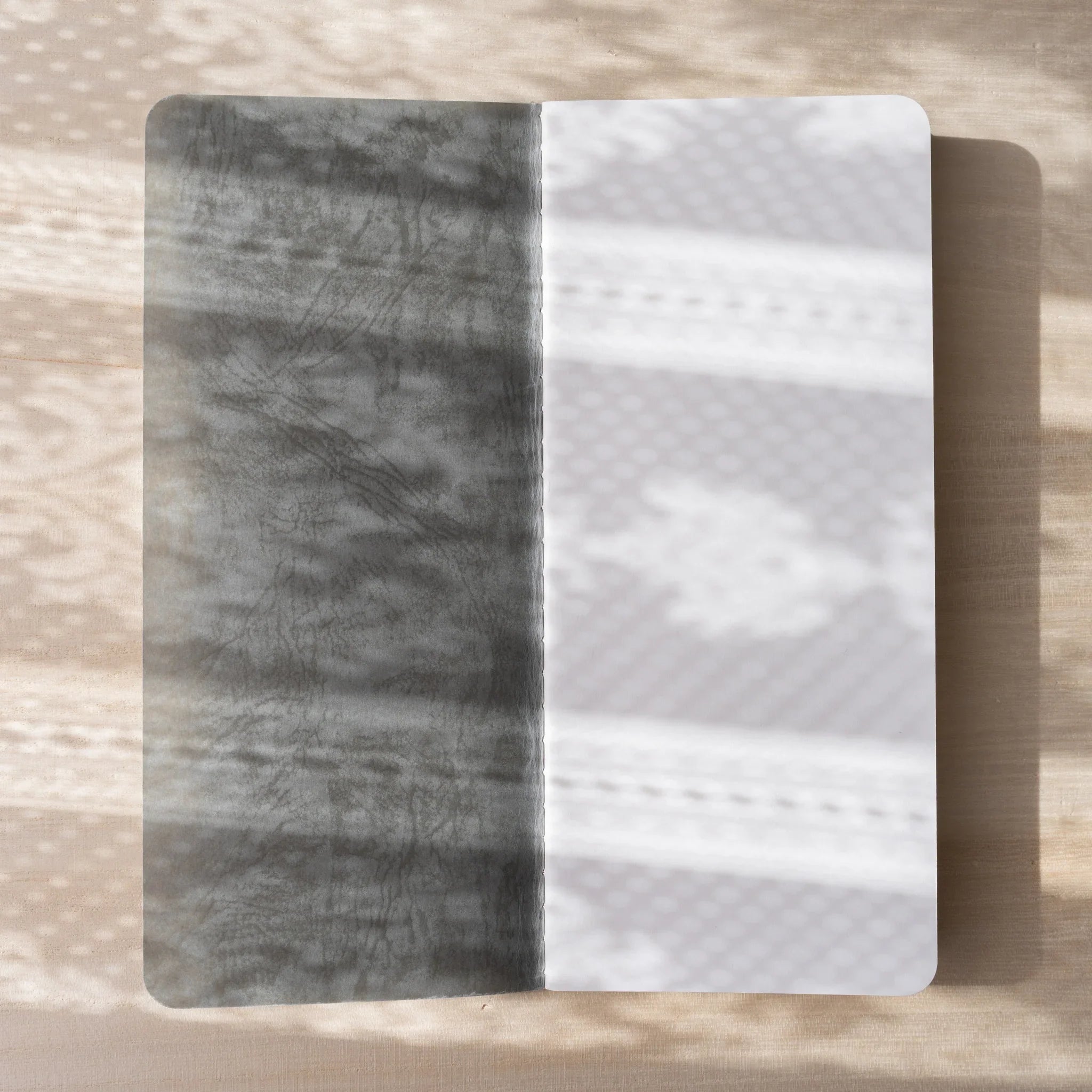 RO-BIKI NOTE Ginnezu gray notebook opened flat showing wax-coated inner cover and translucent glassine endpaper