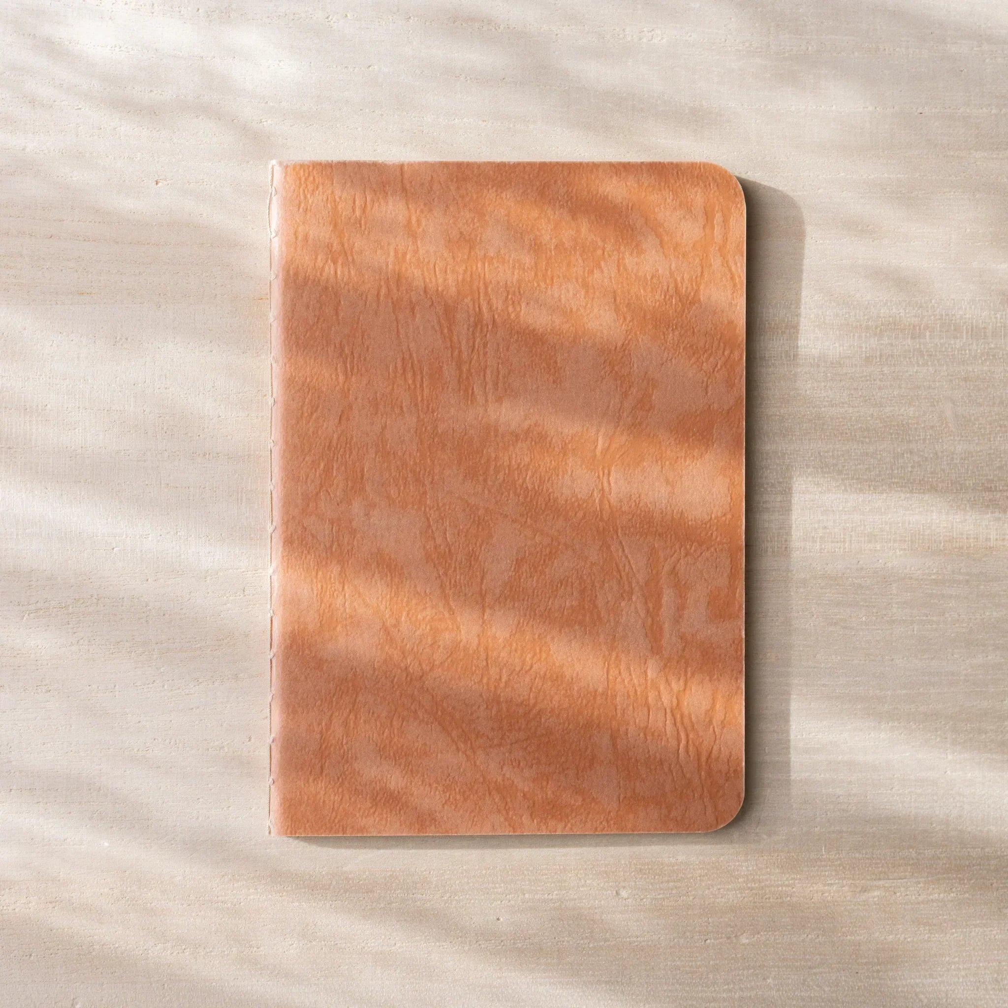 RO-BIKI NOTE open flat, brown waxed kraft inner cover on left, blank white page on right, rounded corners
