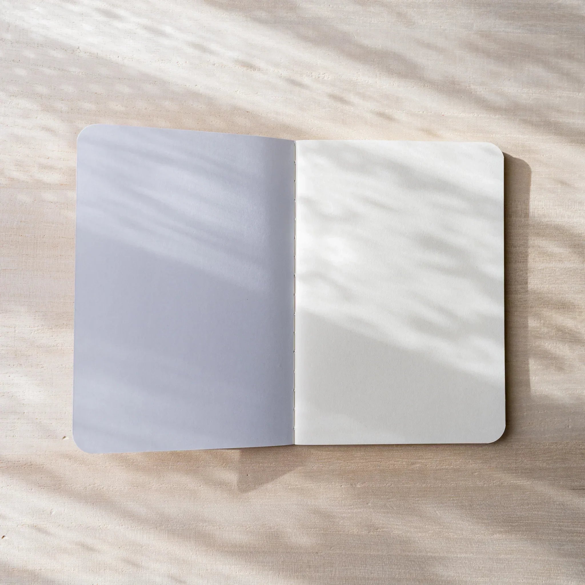 Close-up of RO-BIKI NOTE cream blank page showing paper texture, rounded corner and page edge details visible