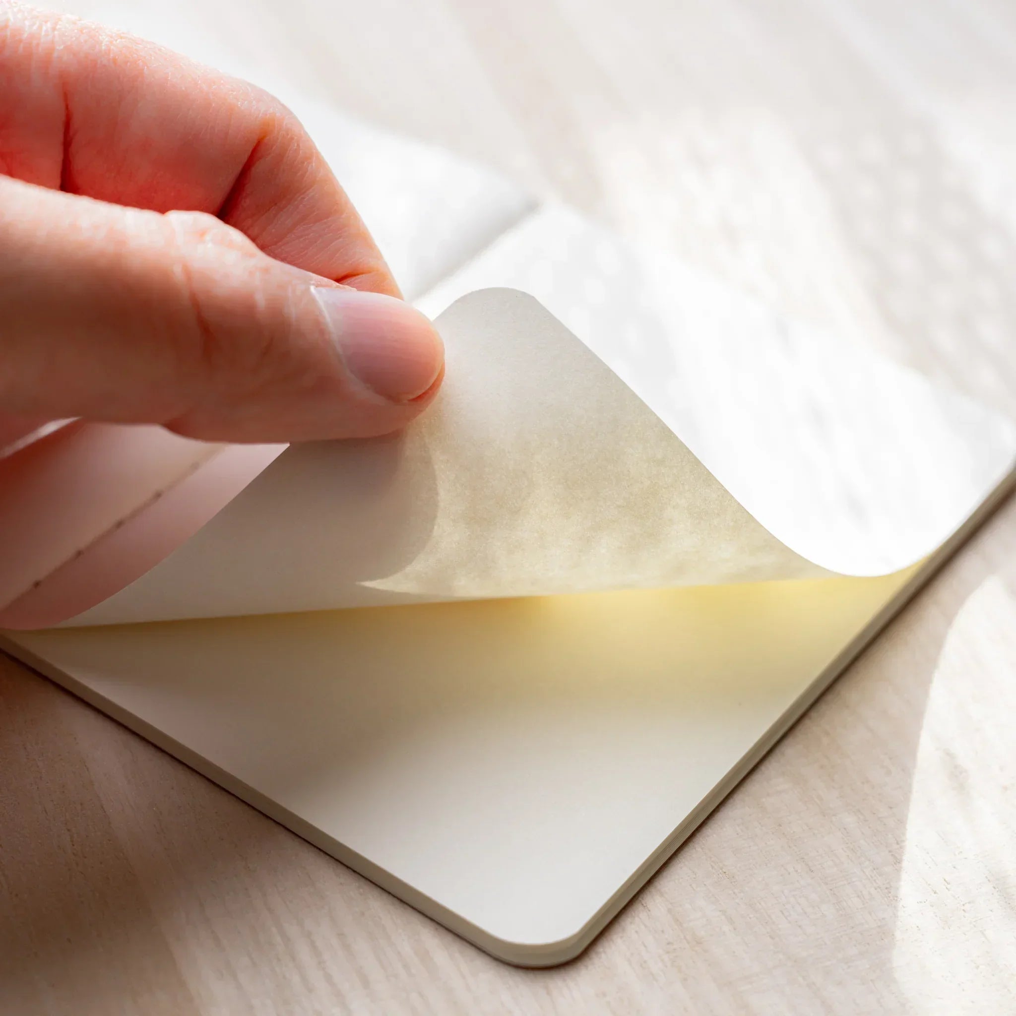 Close-up of RO-BIKI NOTE tonoko beige waxed cover with black spine binding, showing Japanese craft texture
