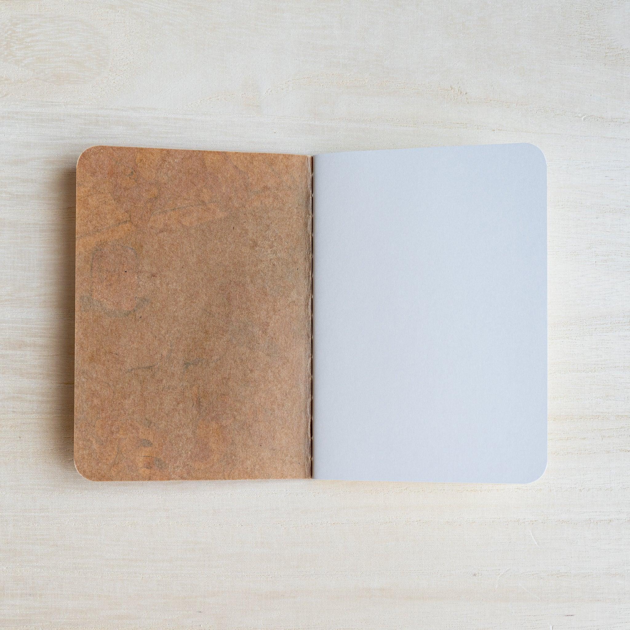 RO-BIKI Kingyo Goldfish notebook opened to the brown kraft inside back cover facing a white end page