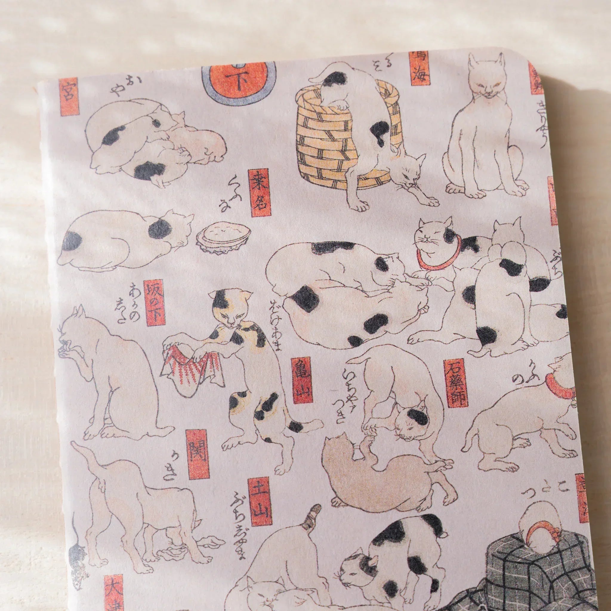 Close-up of RO-BIKI NOTE waxed cover showing black and white cats in various poses with red seals and Japanese text