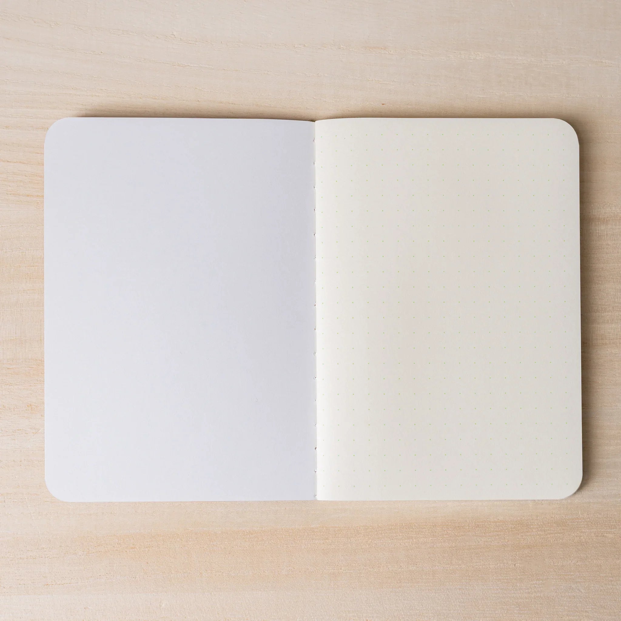 RO-BIKI NOTE open flat, blank white page on left, ivory dot grid page on right, rounded corners and center spine visible