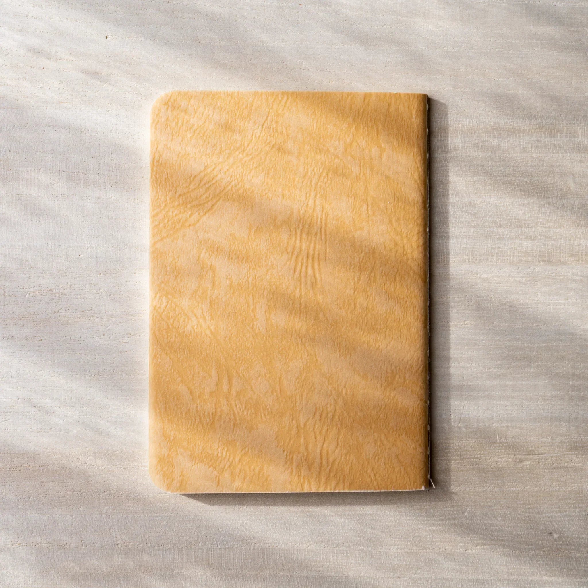 RO-BIKI NOTE stacked closed, tonoko beige and black cover showing rounded corners, Japanese paper quality