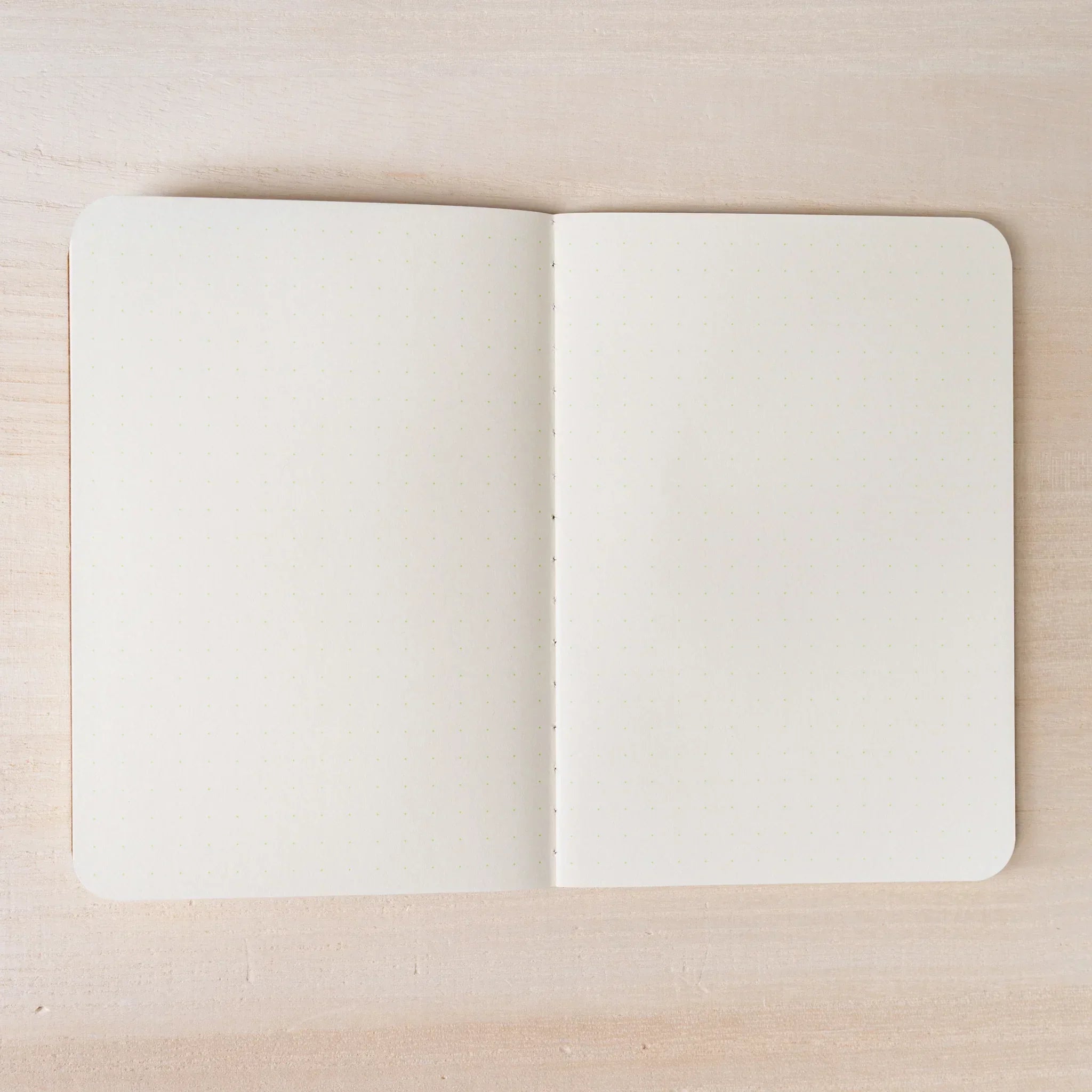 RO-BIKI NOTE open to ivory dot grid spread, both pages with 5mm dot pattern, rounded corners and center spine visible