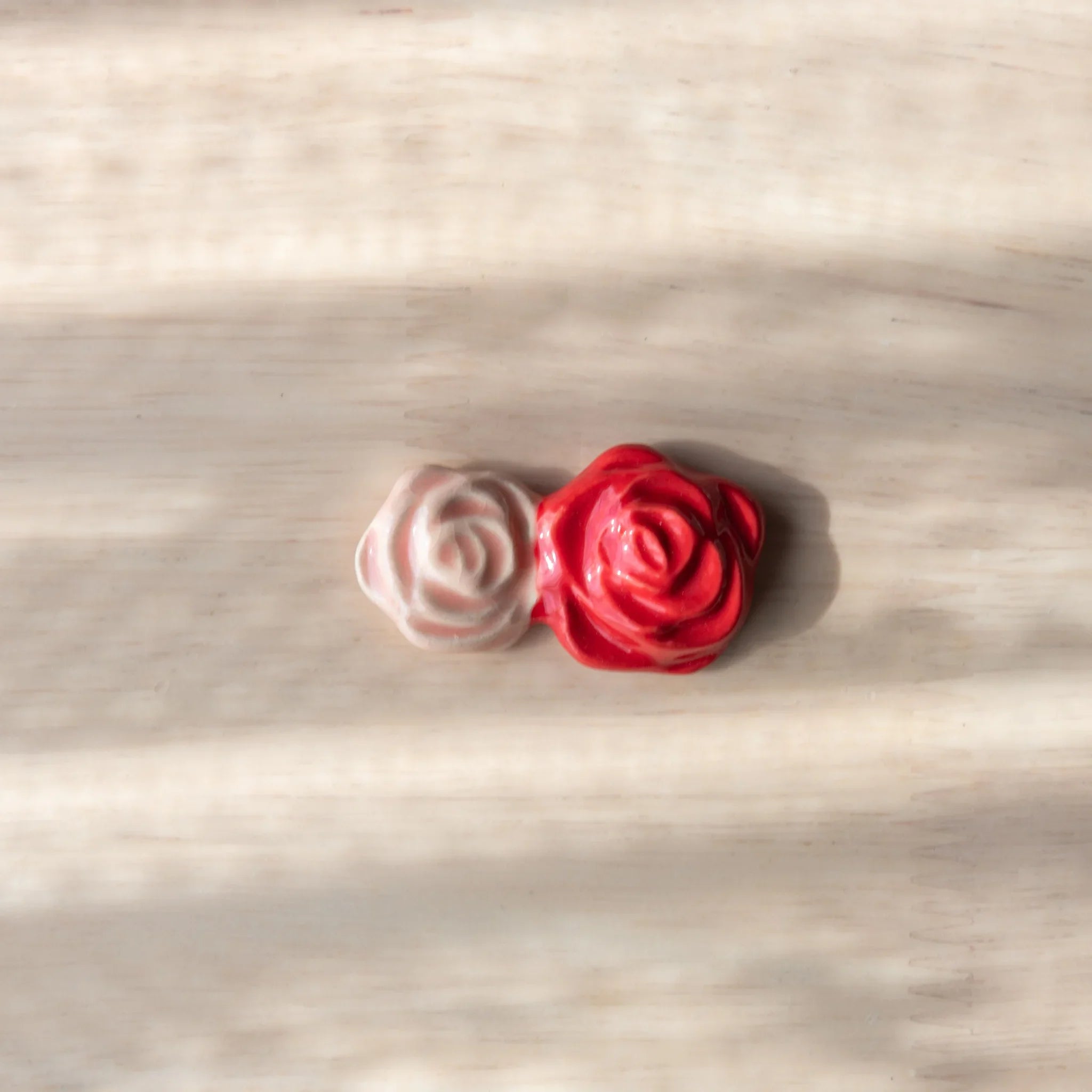 Single red rose handcrafted ceramic pen rest with green leaf support, close-up ceramic detail