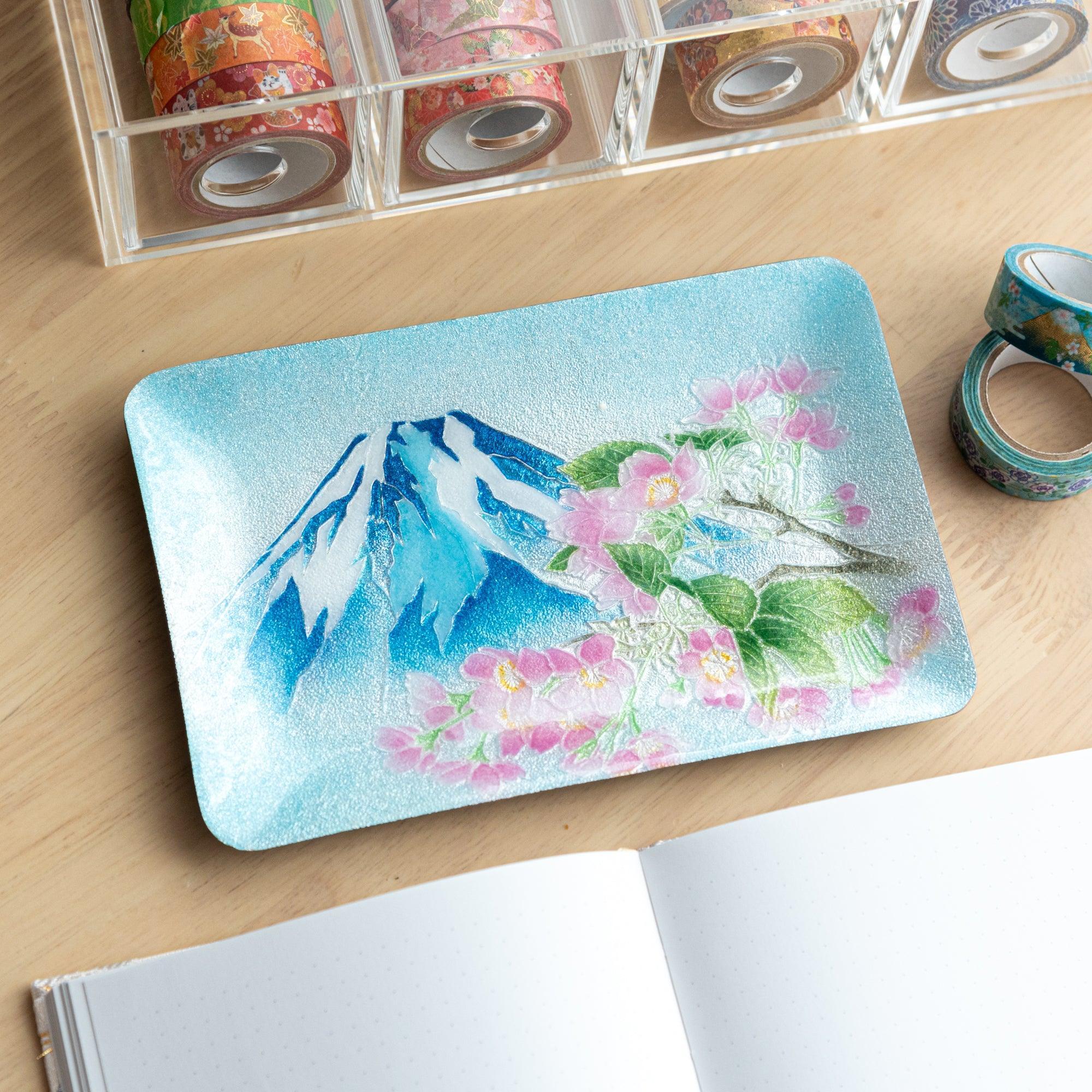 Japanese shippo ware pen tray with blue enamel, Mt. Fuji and pink sakura design, on wood desk with washi tape