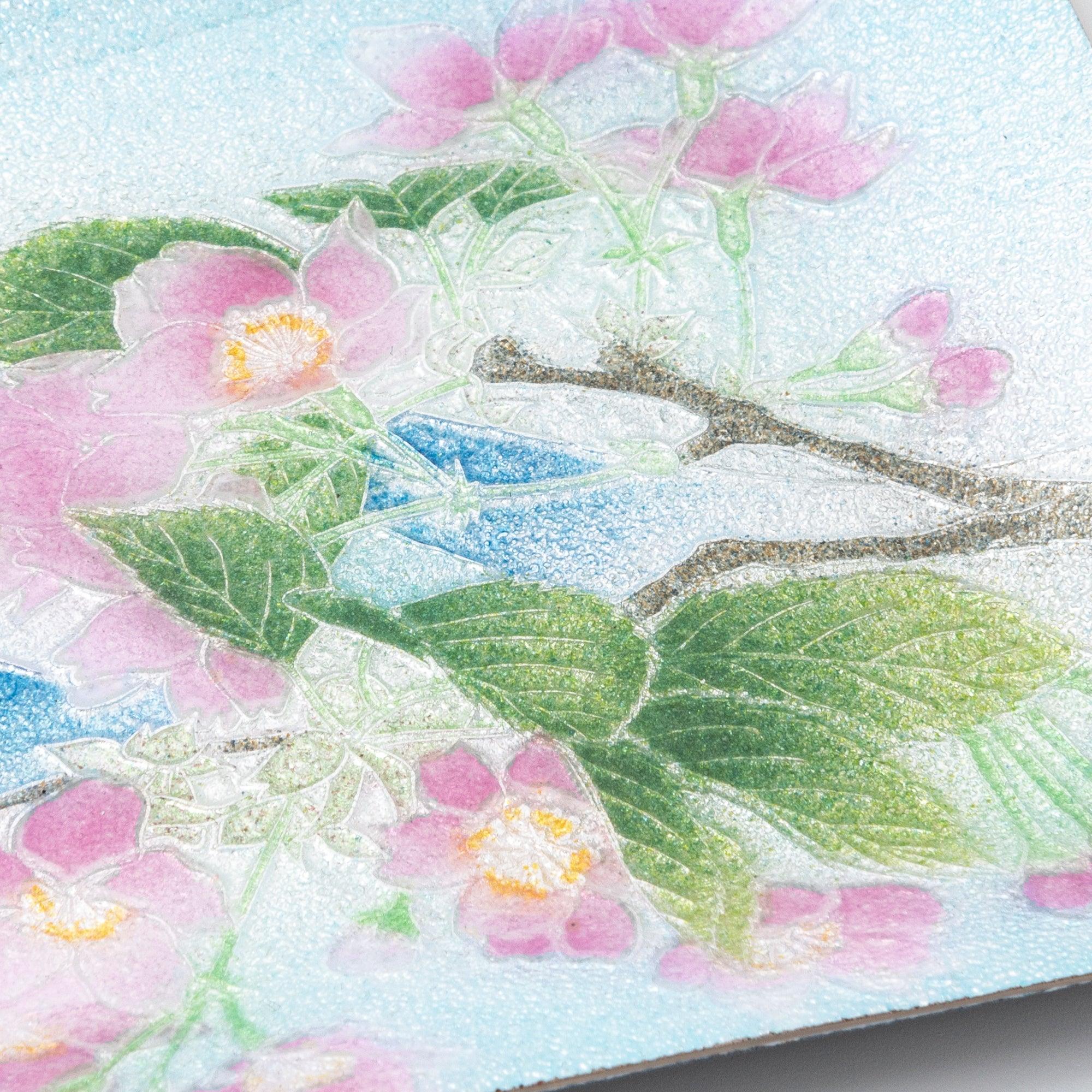 Close-up detail of Japanese shippo ware pen tray showing pink sakura blossoms with yellow stamens and green leaves