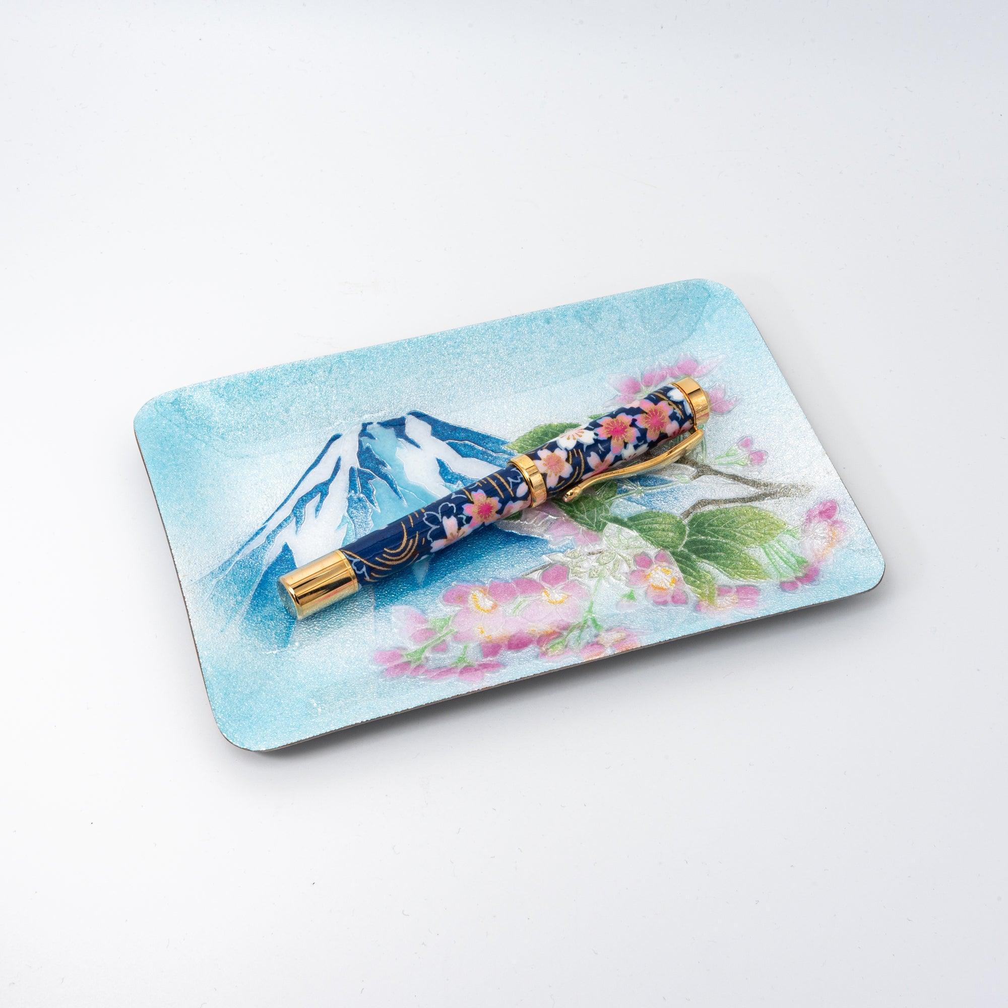 Japanese shippo ware pen tray with Mt. Fuji and sakura design, angled on white surface, blue floral fountain pen inside