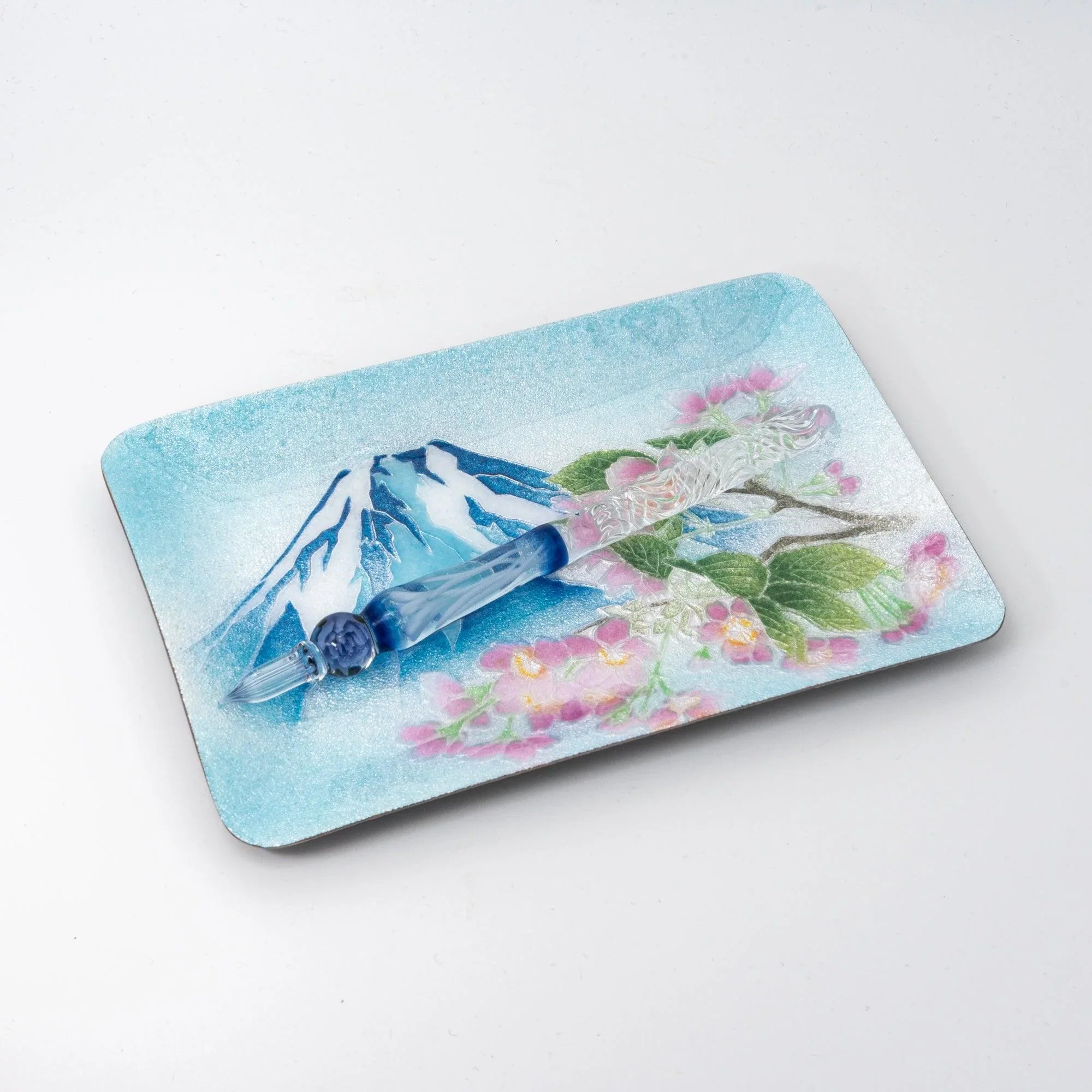 Japanese shippo ware pen tray with Mt. Fuji and sakura design, angled on white surface, clear blue glass dip pen inside