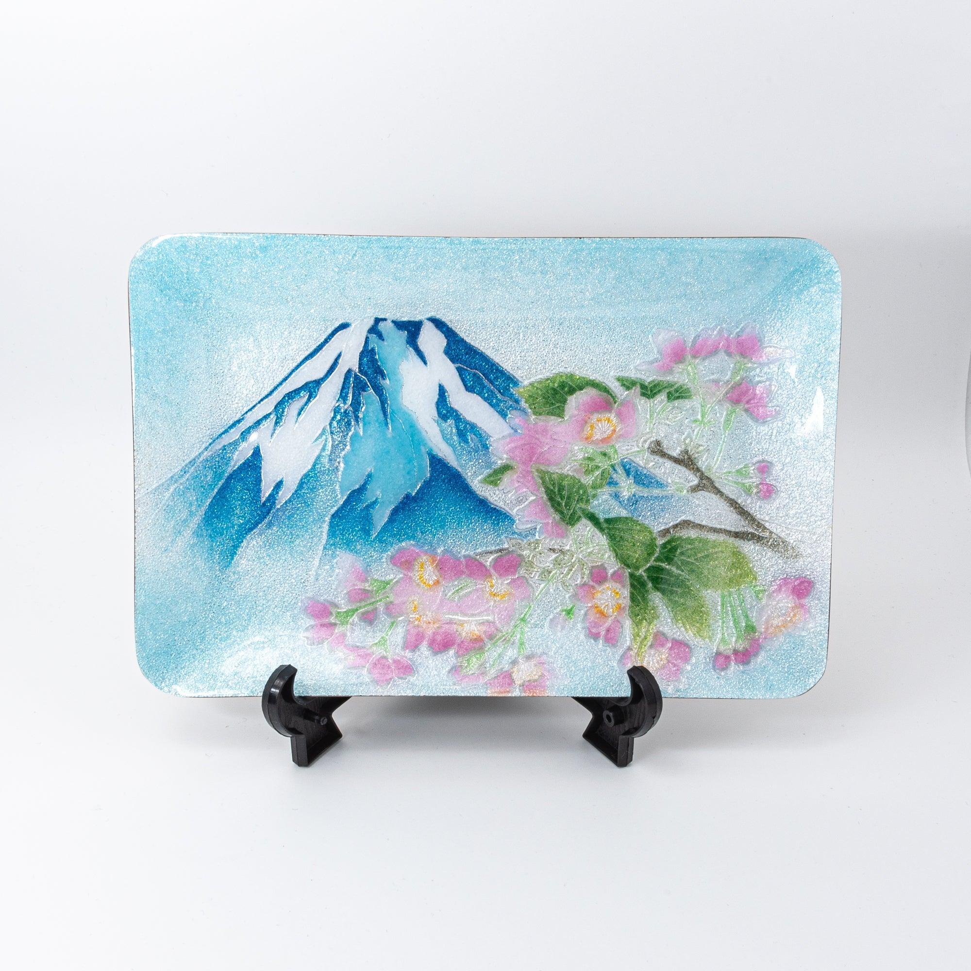 Japanese shippo ware pen tray displayed upright on stand, front view showing Mt. Fuji and pink sakura design on blue enamel