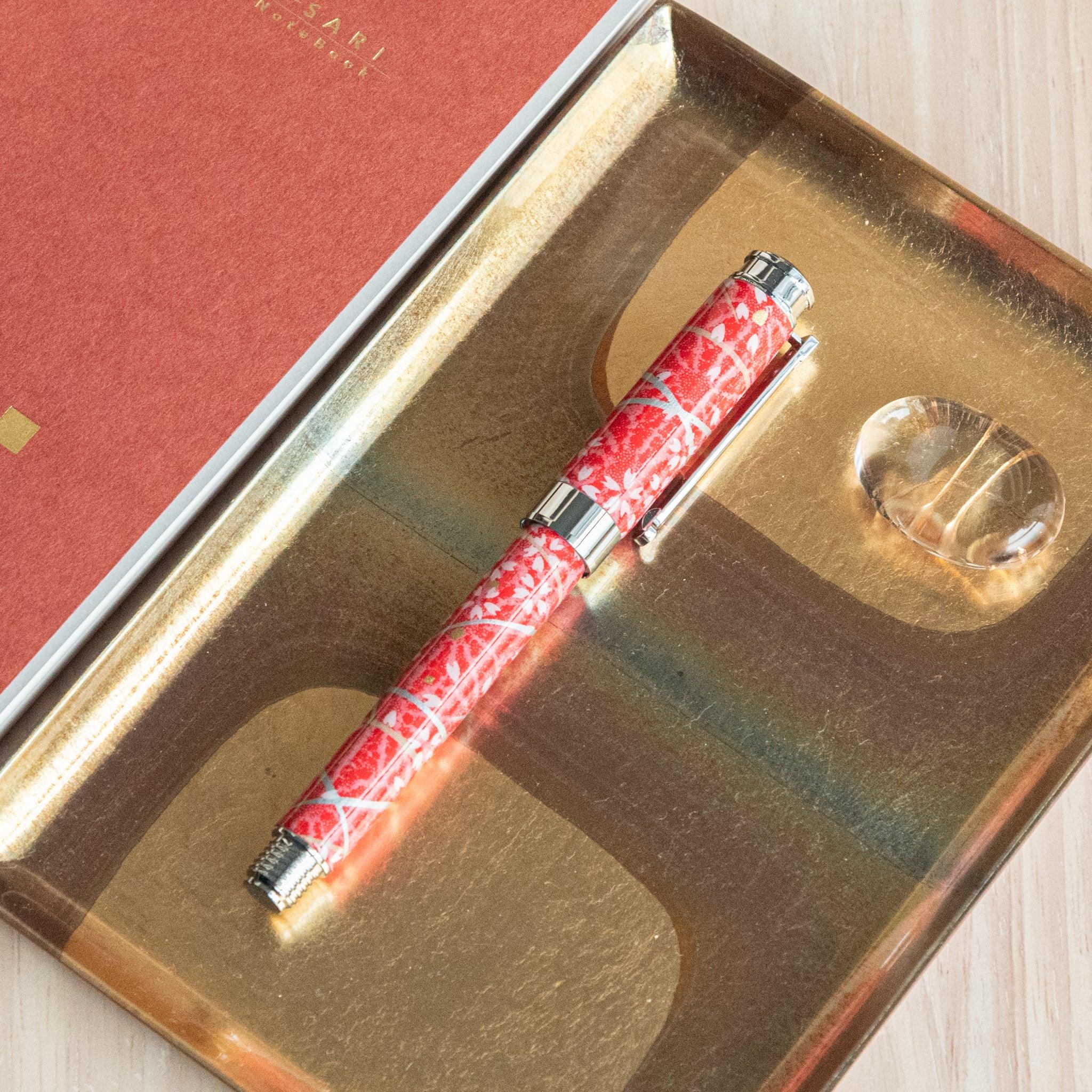 Sakura Hemp fountain pen cap detail on red Mino washi wrapper decorated with white cherry blossoms and green hemp leaves