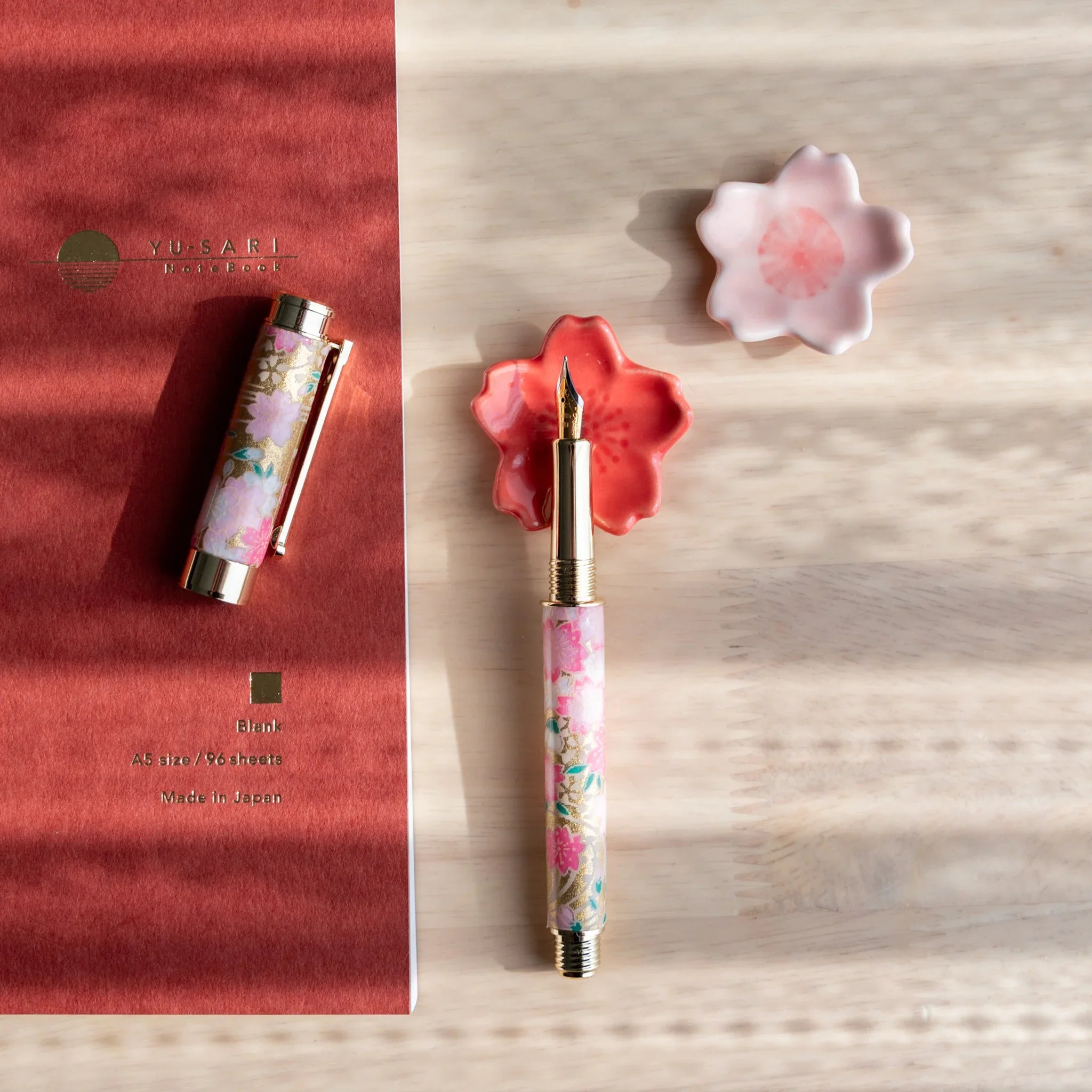 Sakura flower pen rest with pale pink petals showing Japanese cherry blossom handcrafted design and detailed petal carving