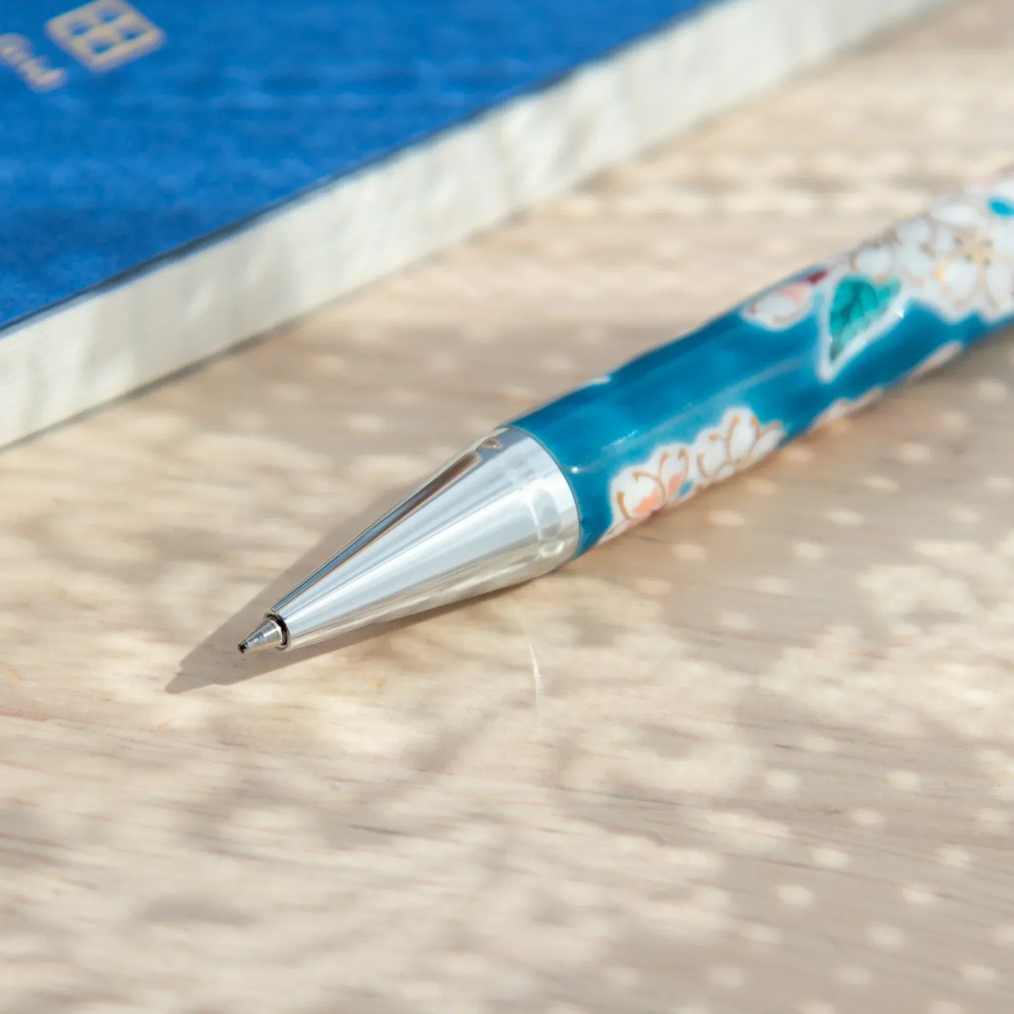 Close-up of Sakura Kutani Japanese Ballpoint Pen showing pen tip and vivid ceramic floral detailing.
