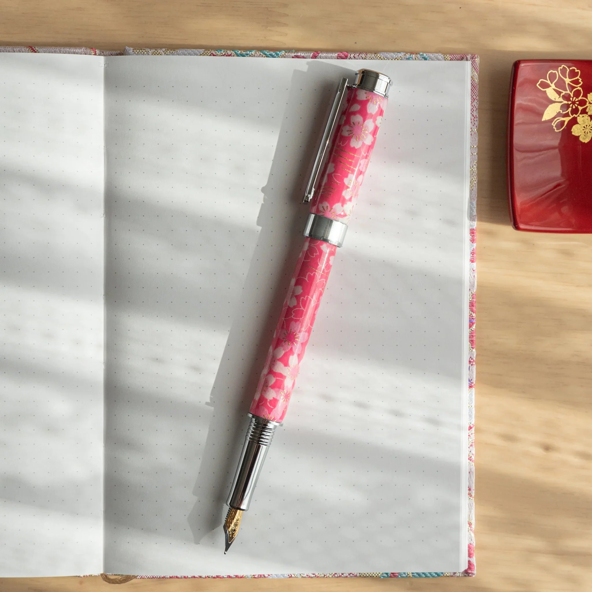 Sakura Over the River Mino Washi fountain pen barrel showing pink cherry blossoms over water landscape with nib