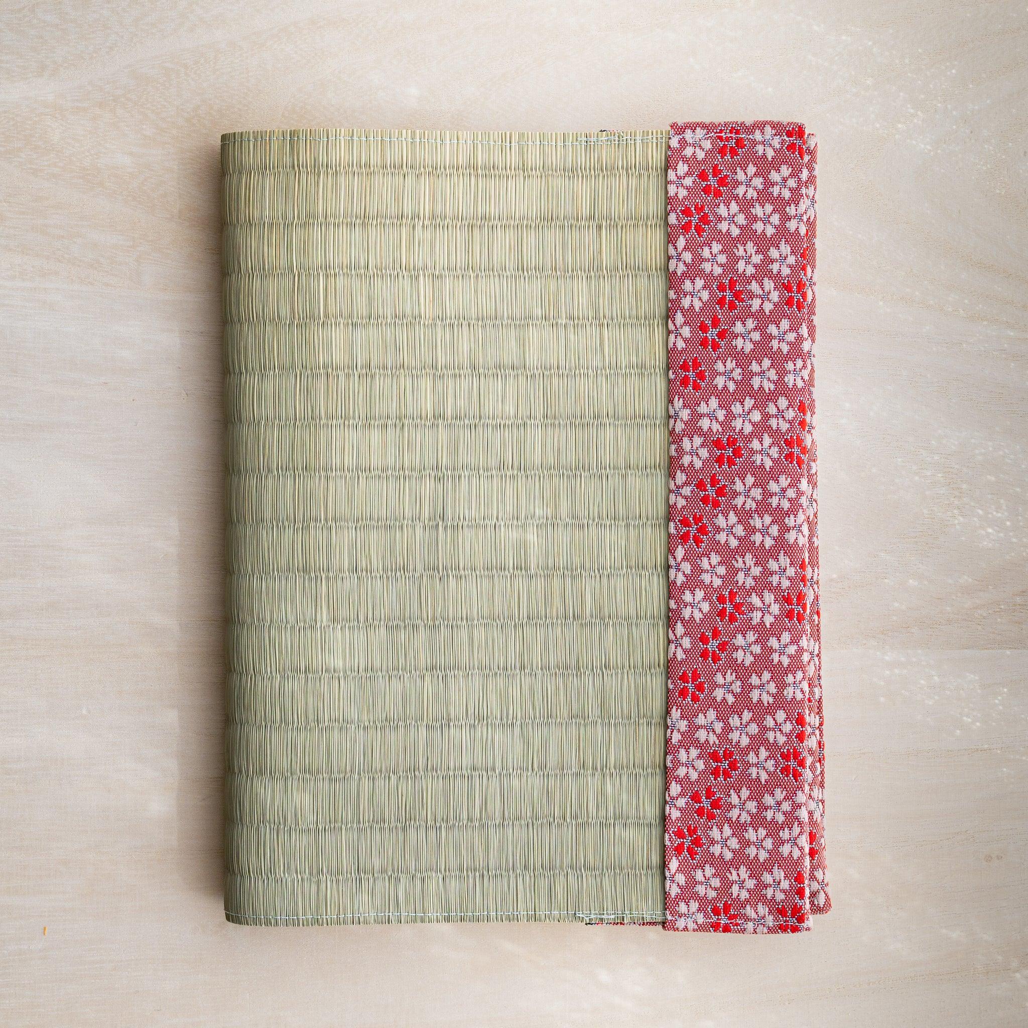 Sakura tatami book cover closed, woven green rush straw with pink and red Japanese cherry blossom fabric band