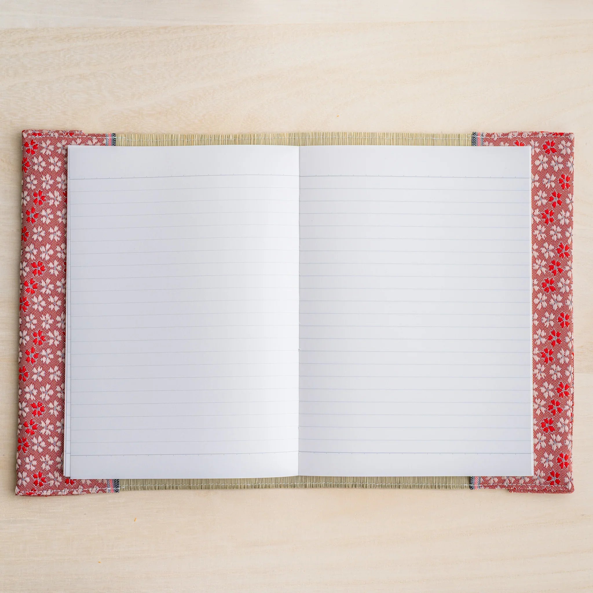 Tatami book cover open flat with white lined notebook pages, Japanese cherry blossom fabric edges both sides