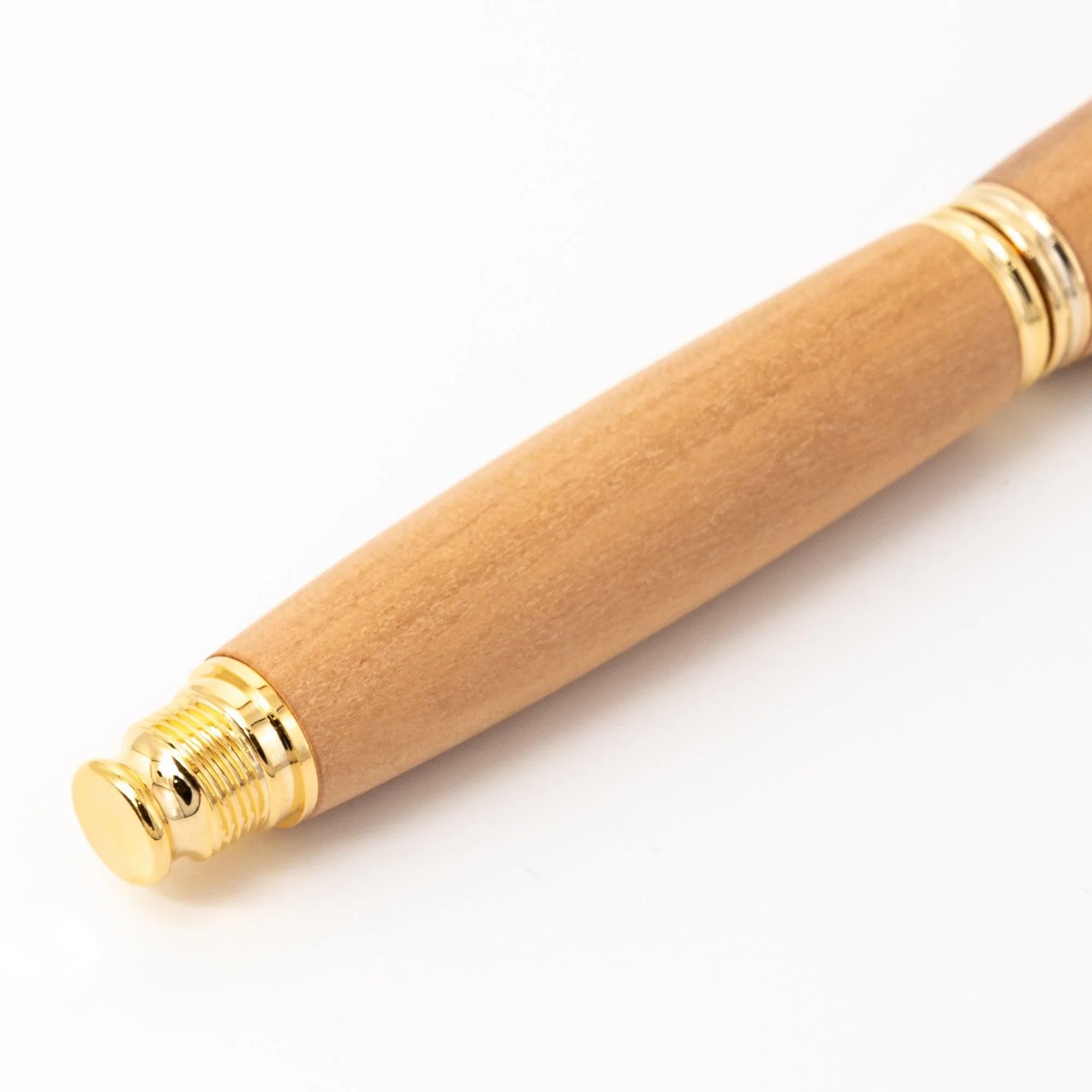 Close-up of natural wood fountain pen barrel tail with gold threaded end, trim rings, and wood grain on white background