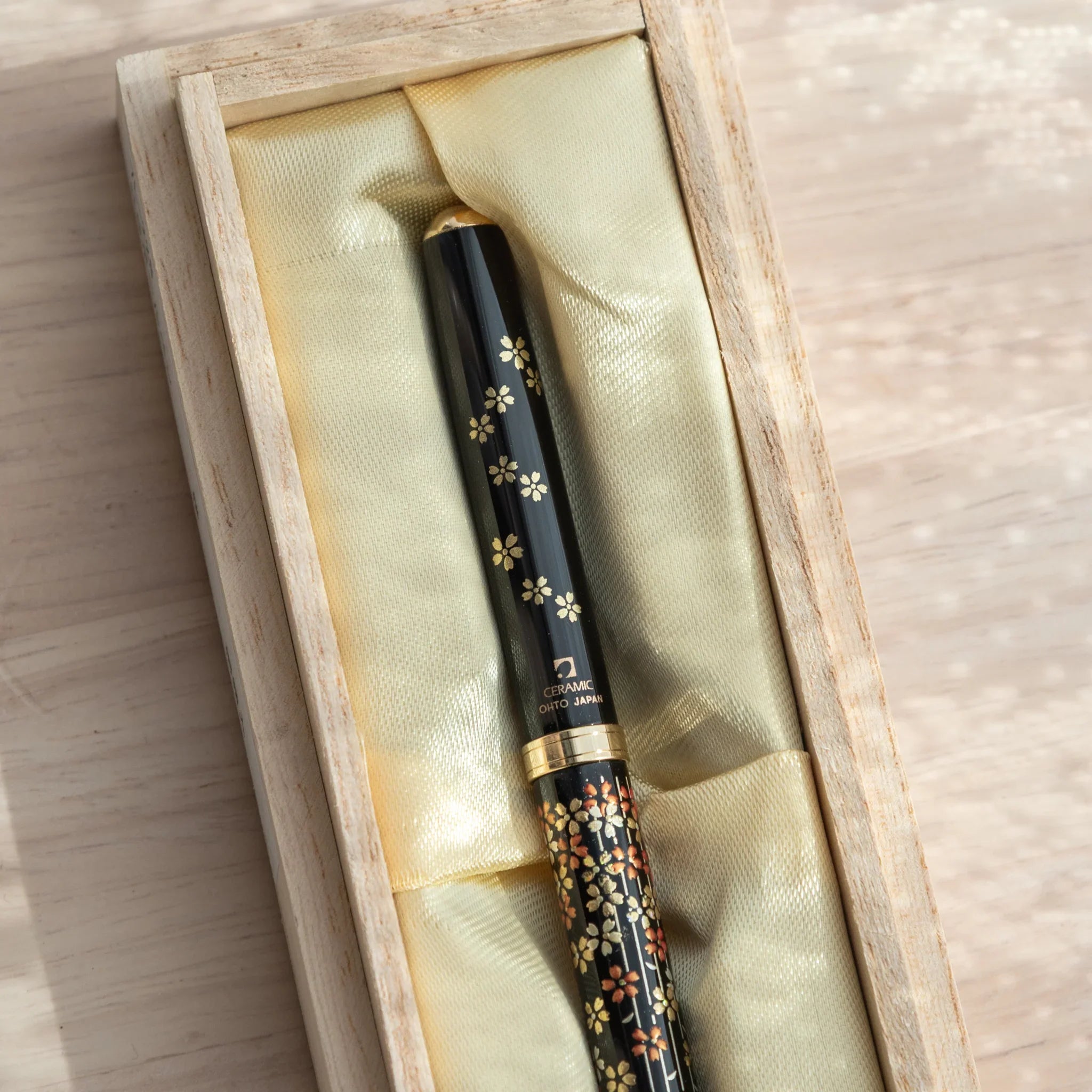 Hand-finished Yamanaka ballpoint pen features spring sakura blossoms and botanical foliage elements made