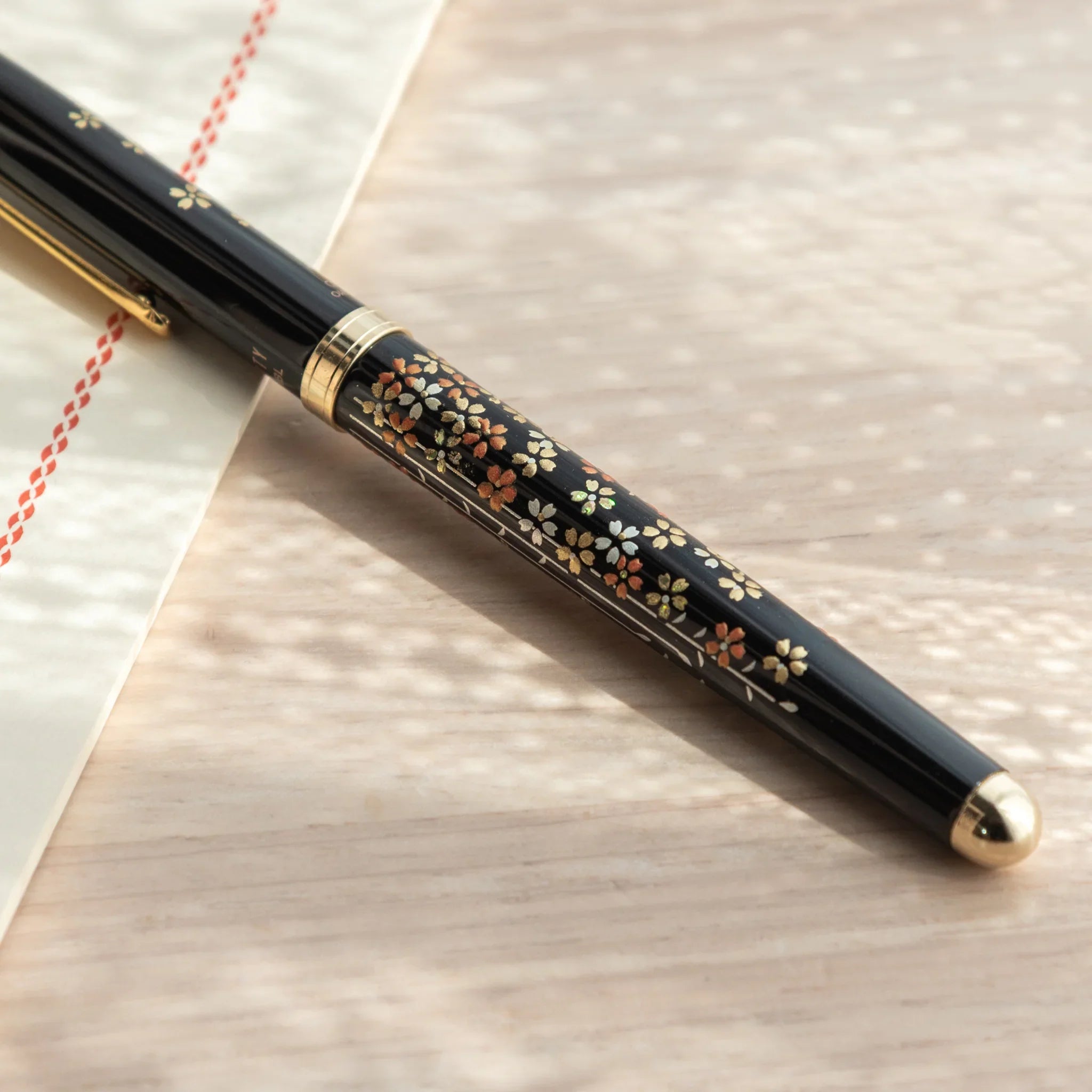 Japanese Yamanaka lacquer ballpoint pen features pink sakura cherry blossom flower and tree branches