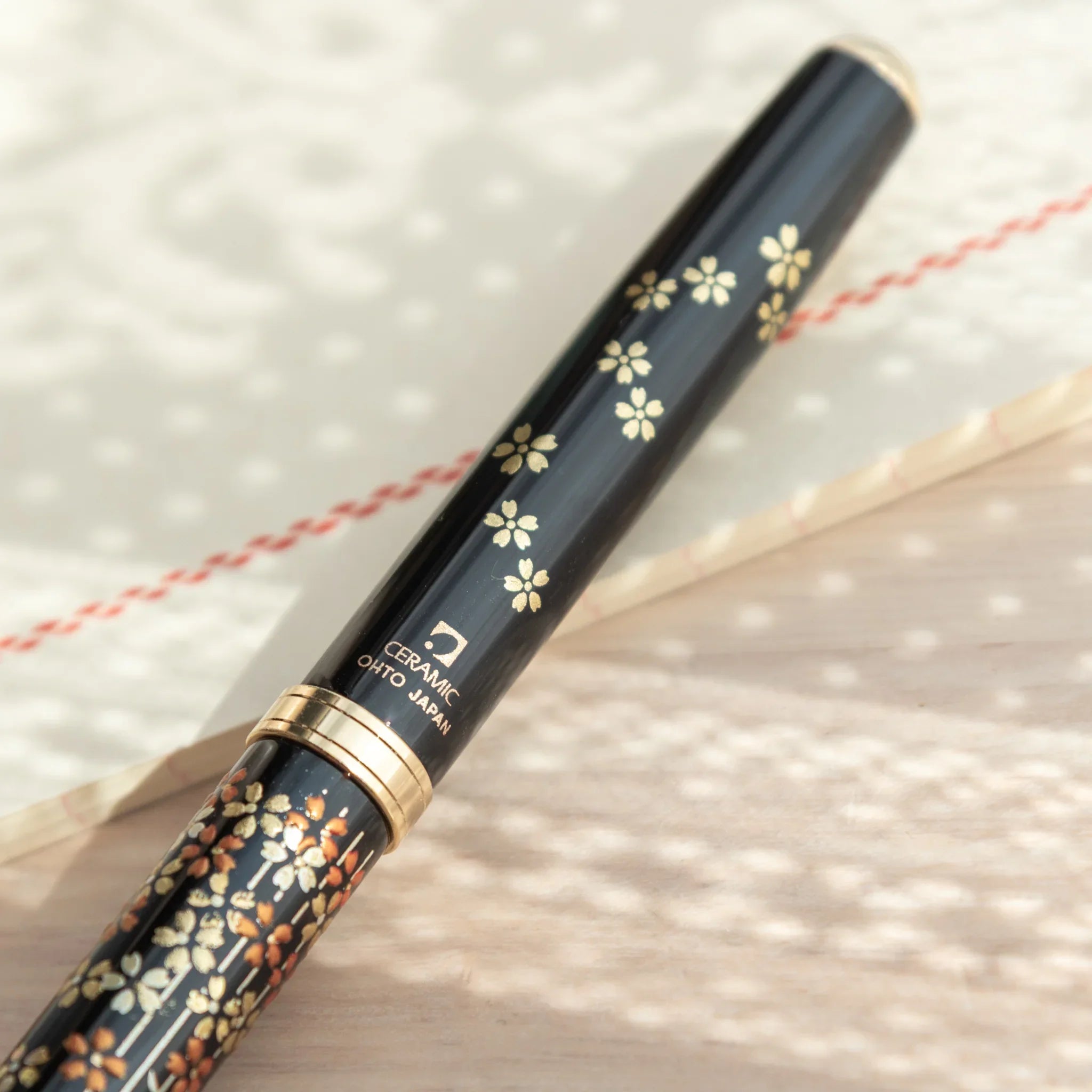 Hand-turned Yamanaka wooden ballpoint pen features delicate sakura flowers and branch lacquer art for writing