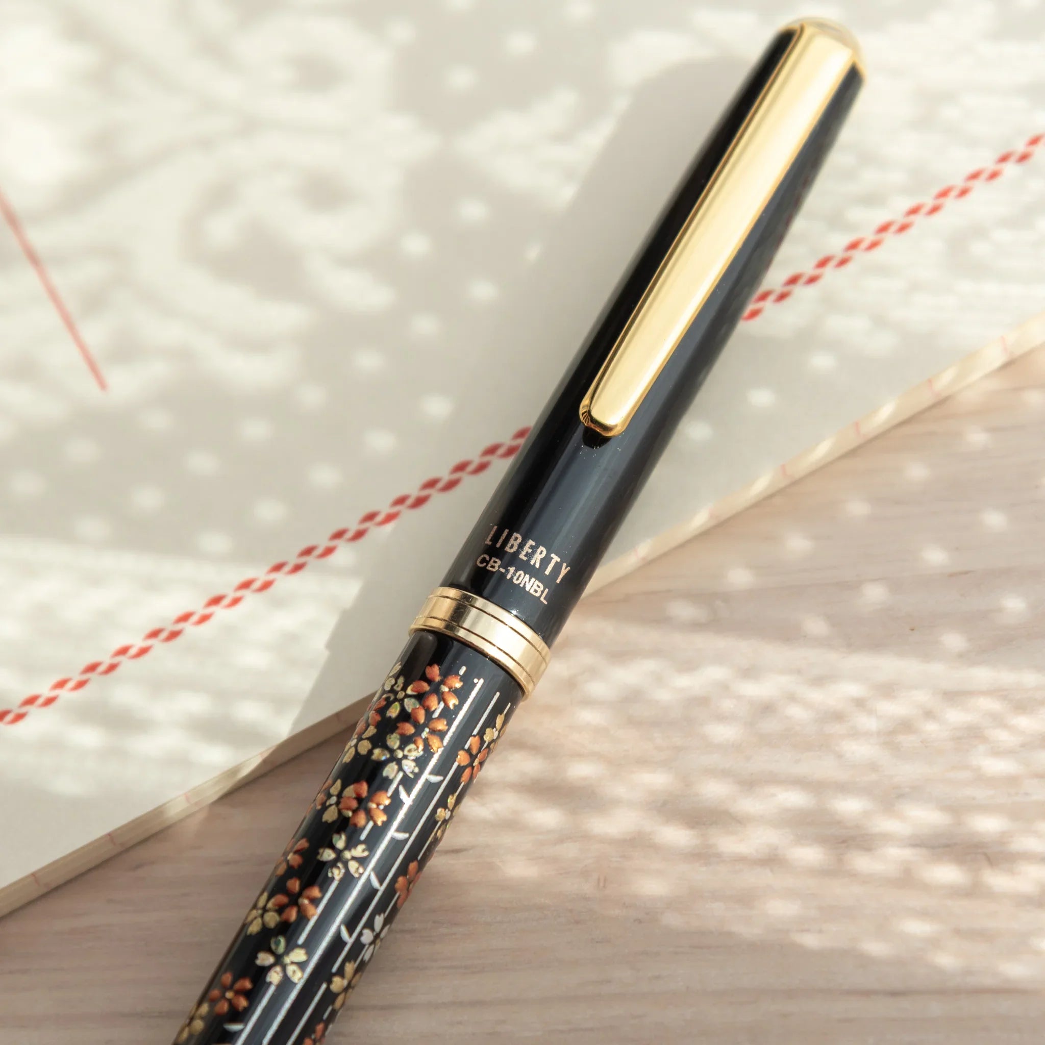 Traditional Yamanaka lacquered ballpoint pen depicts spring cherry blossoms and botanical branches made