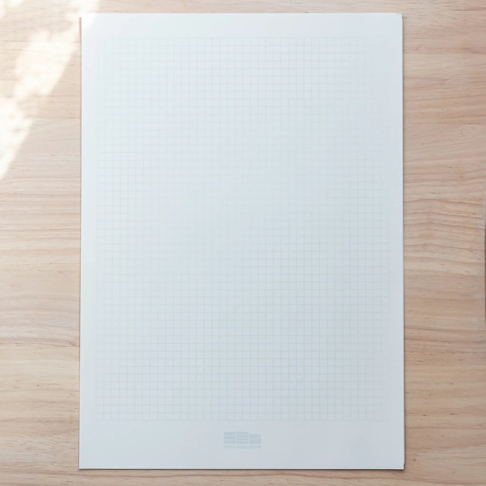 Grid guide sheet included with Sanzen Tomoe River Japanese Loose Leaf Paper A4, aiding smooth writing alignment.