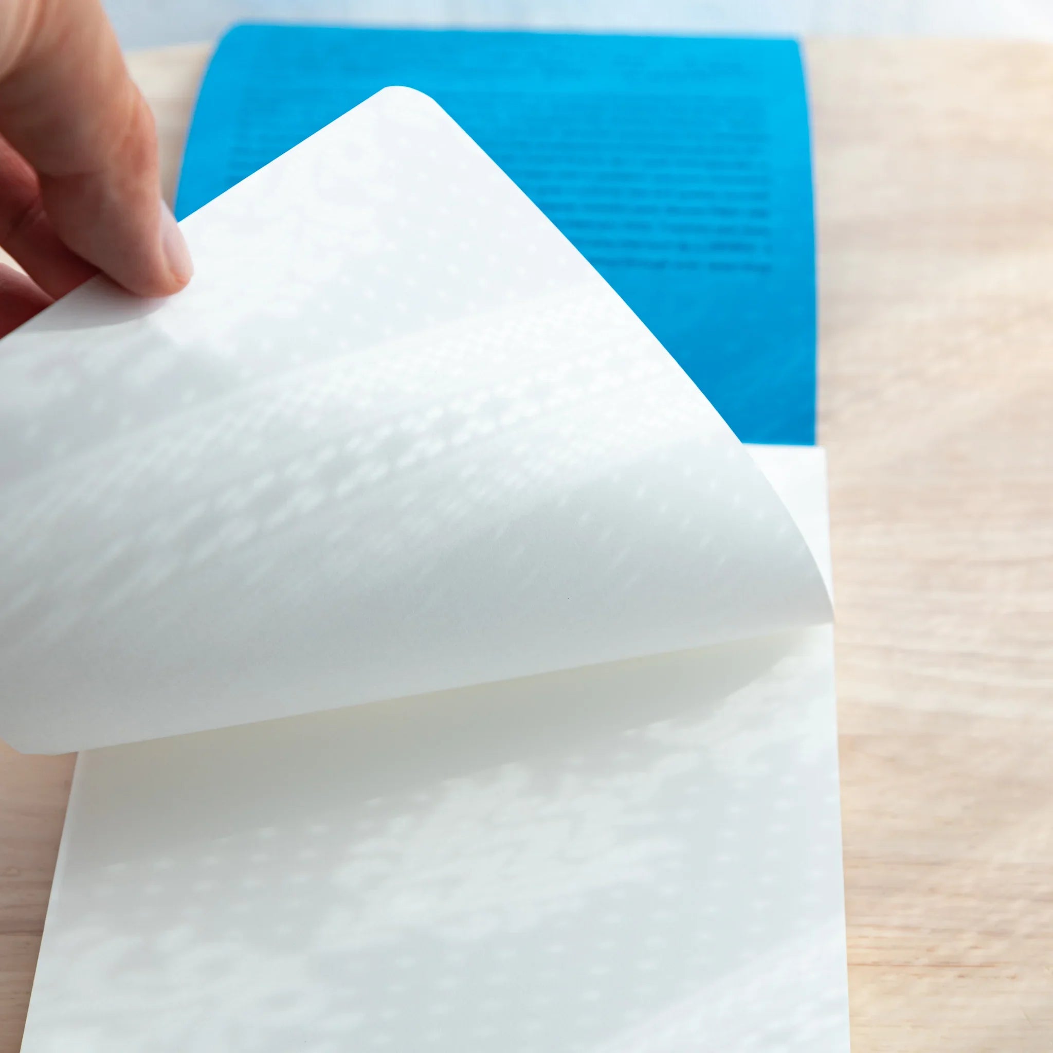 Turning a page of Sanzen Tomoe River A5 Japanese Writing Pad, thin smooth sheets perfect for fountain pen testing.