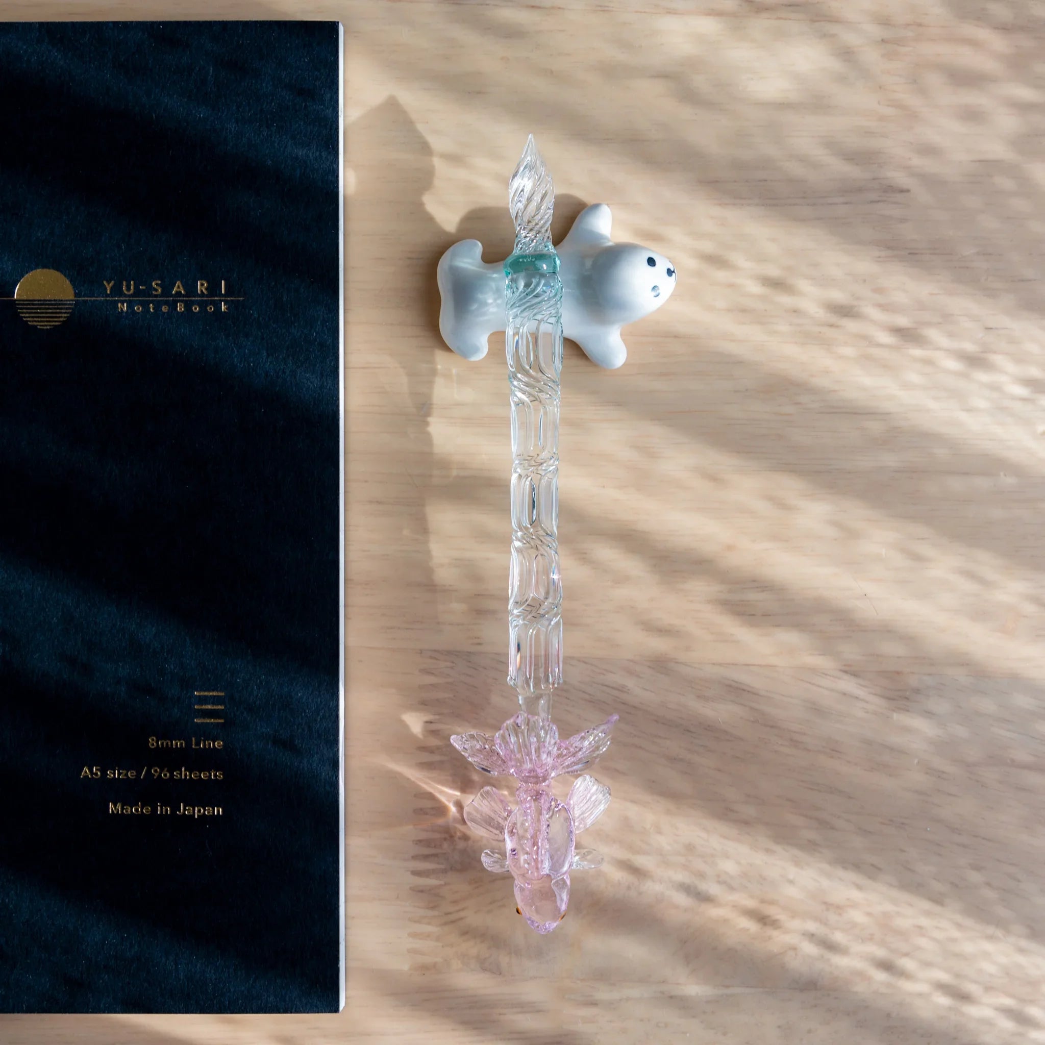 Seal-shaped handcrafted ceramic pen rest in neutral gray close shot