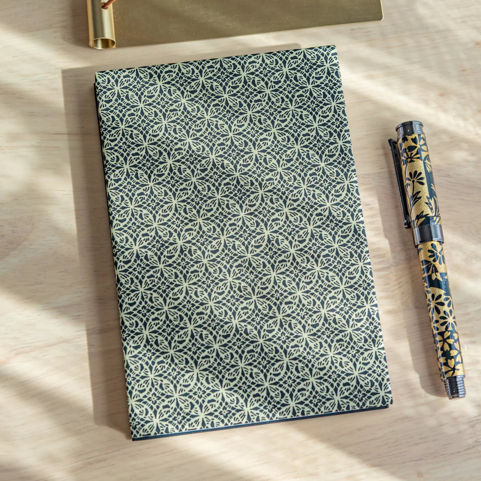 Shippo Pattern washi goshuincho front cover in dark navy with cream interlocking circle pattern, displayed with matching pen
