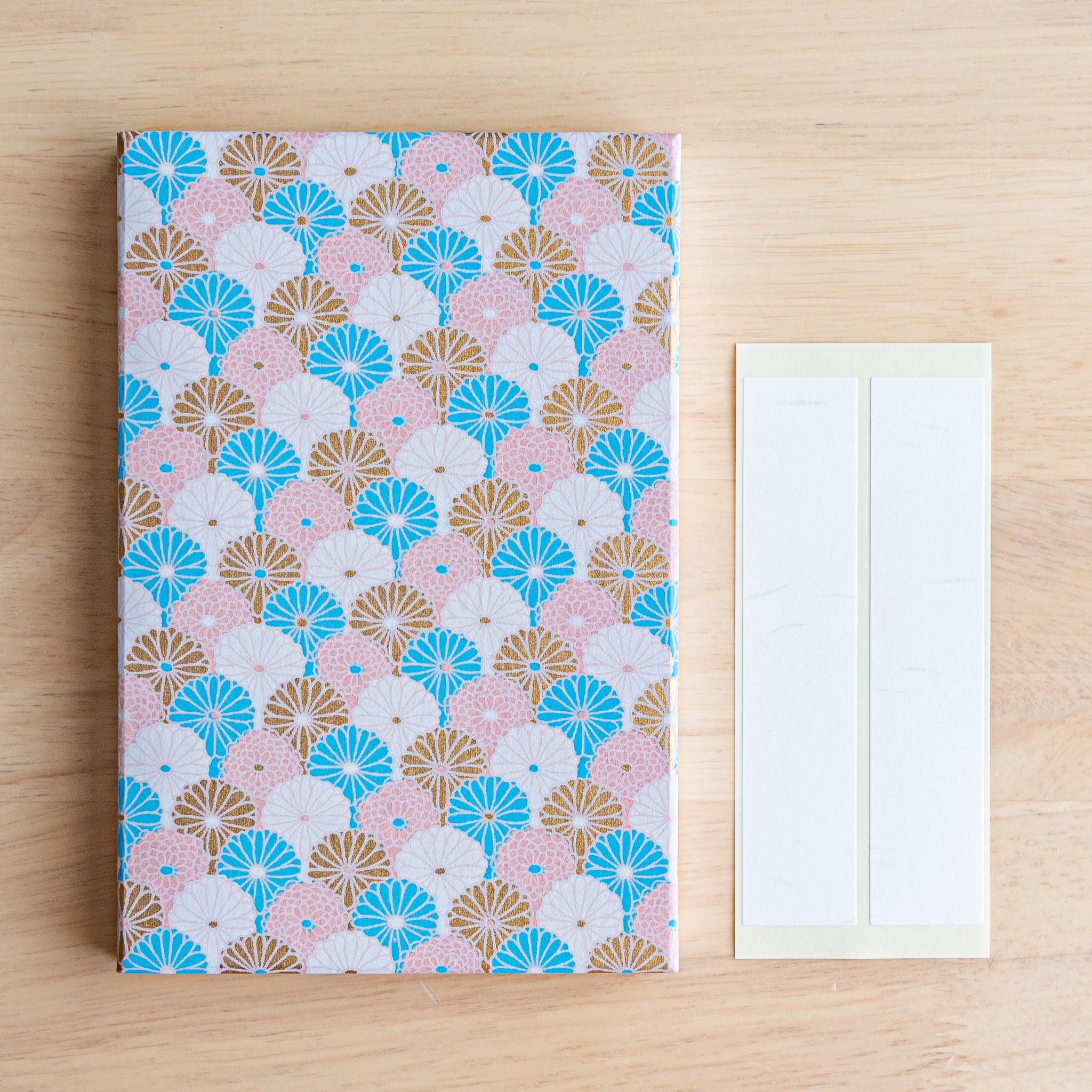 Soft pastel Goshuinsho stamp book with fan-like chrysanthemum design and included label sheets from Japan.