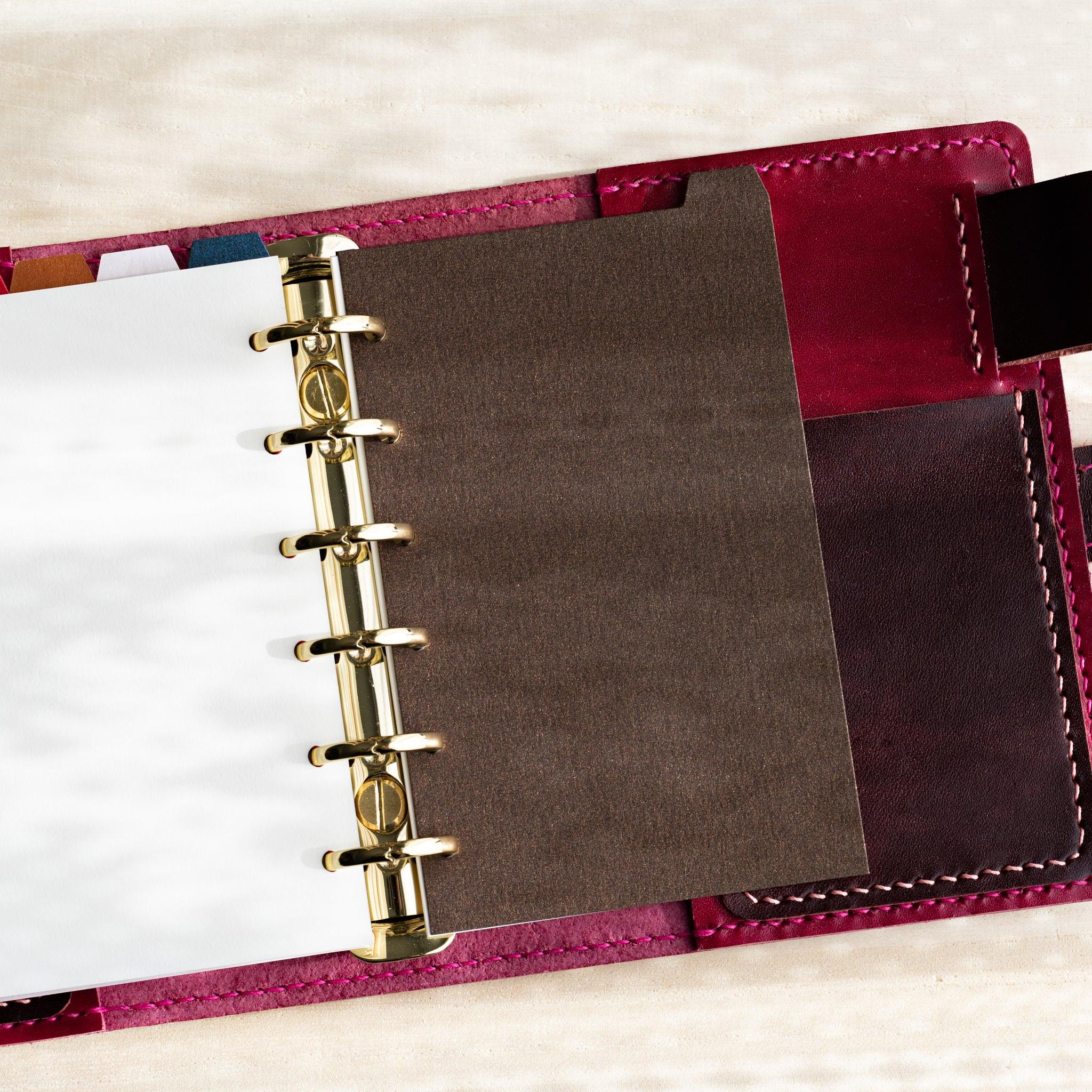 Japanese Stationery Stardream index divider for Mini 6 planners in brown inserted in a gold-ring planner with colorful tabs.