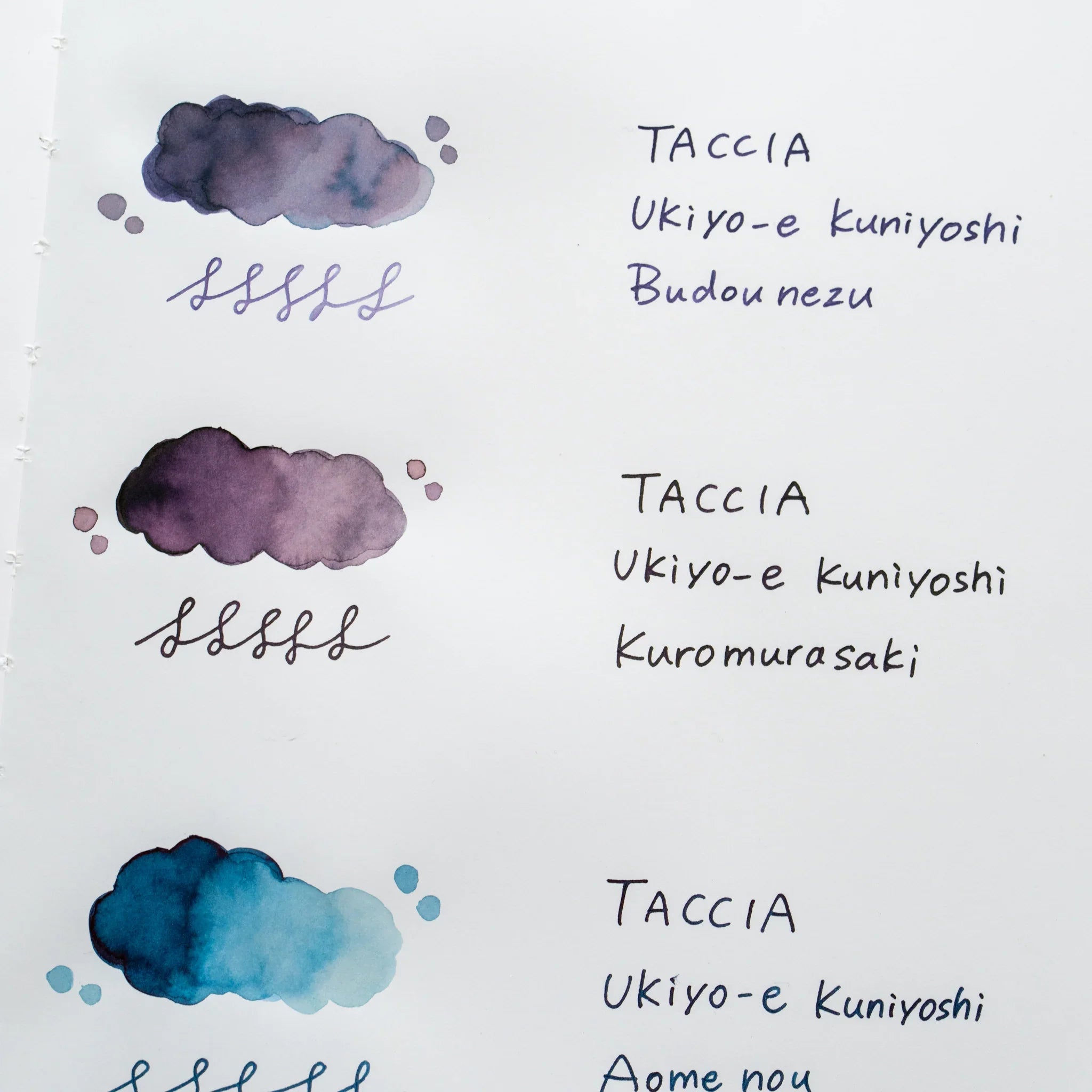 TACCIA Ukiyo-e Kuniyoshi Kuromurasaki hand-painted swatch shown with neighboring ink colors on YU-SARI notebook.