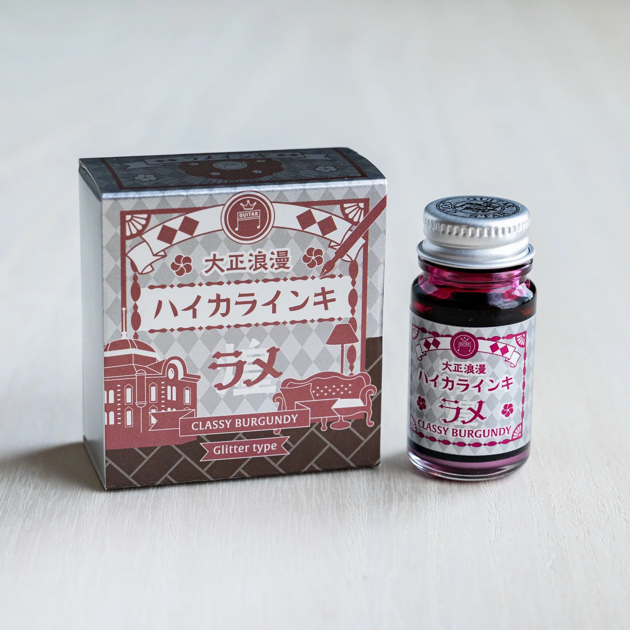 Taisho Romance Classy Burgundy Shimmer Ink silver foil box beside a 12 ml glass bottle of wine red glitter ink