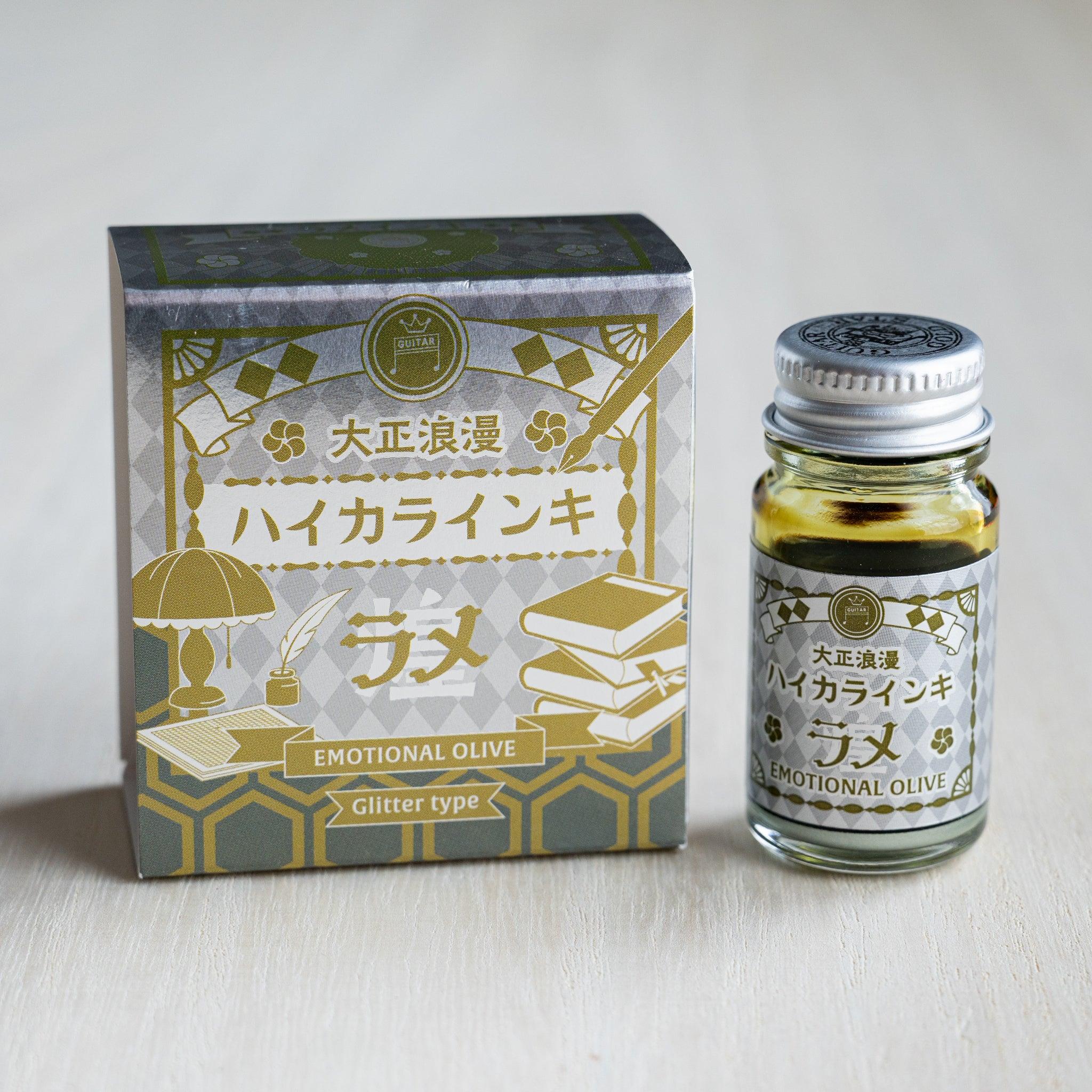 Taisho Romance Emotional Olive Shimmer Ink silver foil box beside a 12 ml glass bottle of olive green glitter ink