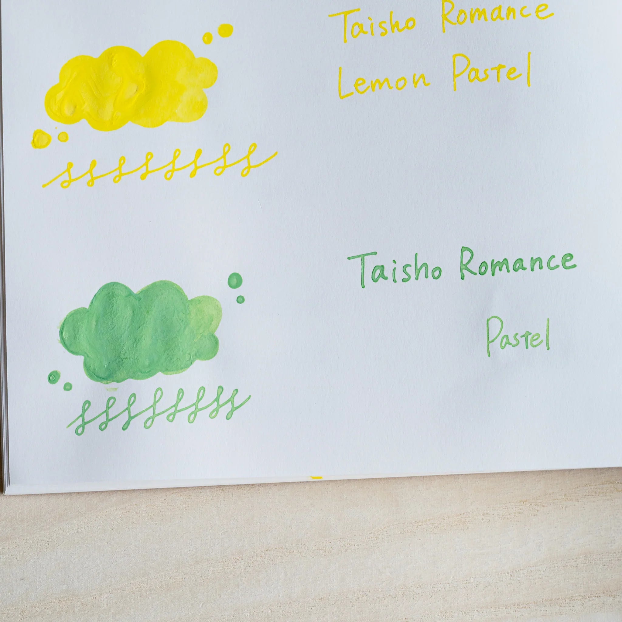 Handwritten swatch of Taisho Romance Jade Pastel ink, a cloud-shaped wash and a looped line in grass green